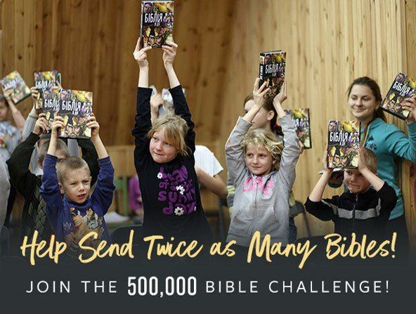 A group of children are holding up bible books in their hands.