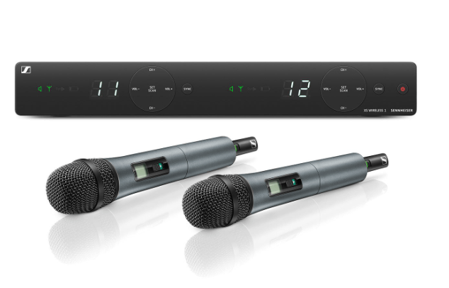 Two microphones are sitting next to each other on a white surface.