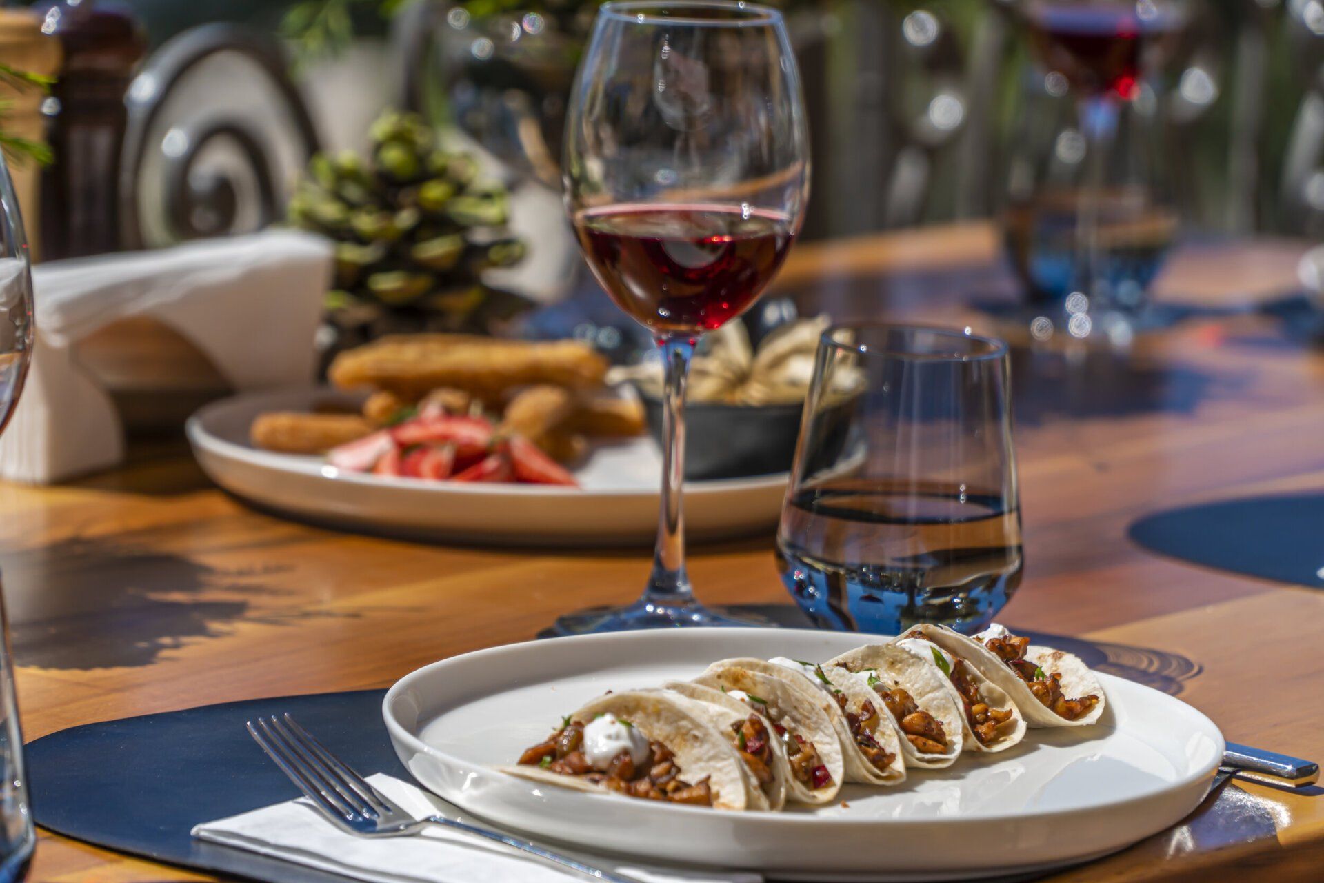 A plate of food and a glass of wine on a table.