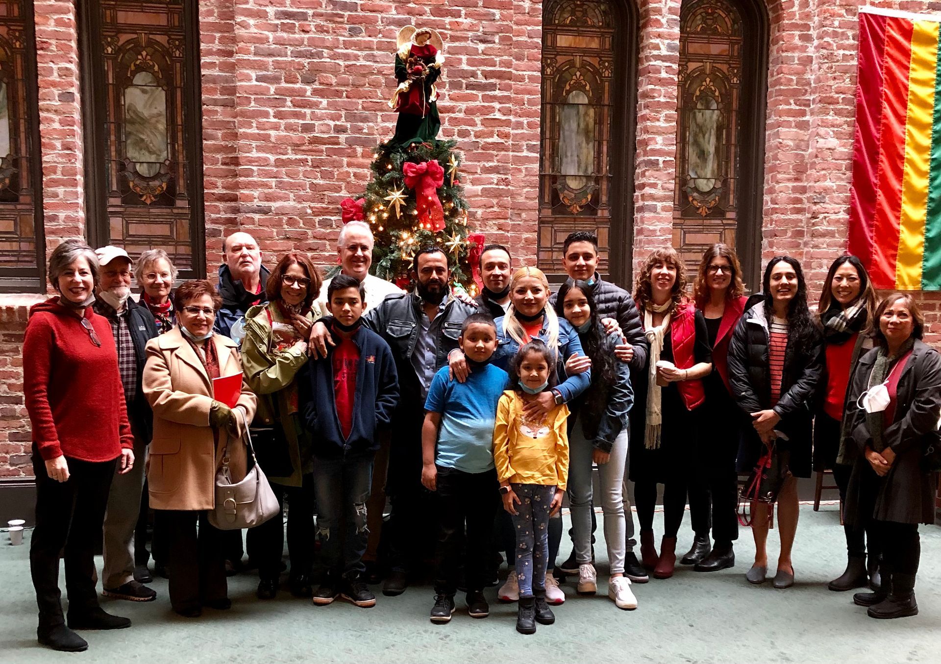 A large crowd of people posing for a picture during Christmas time in our Atrium. These are families that have participated in our Living Sanctuary Ministry