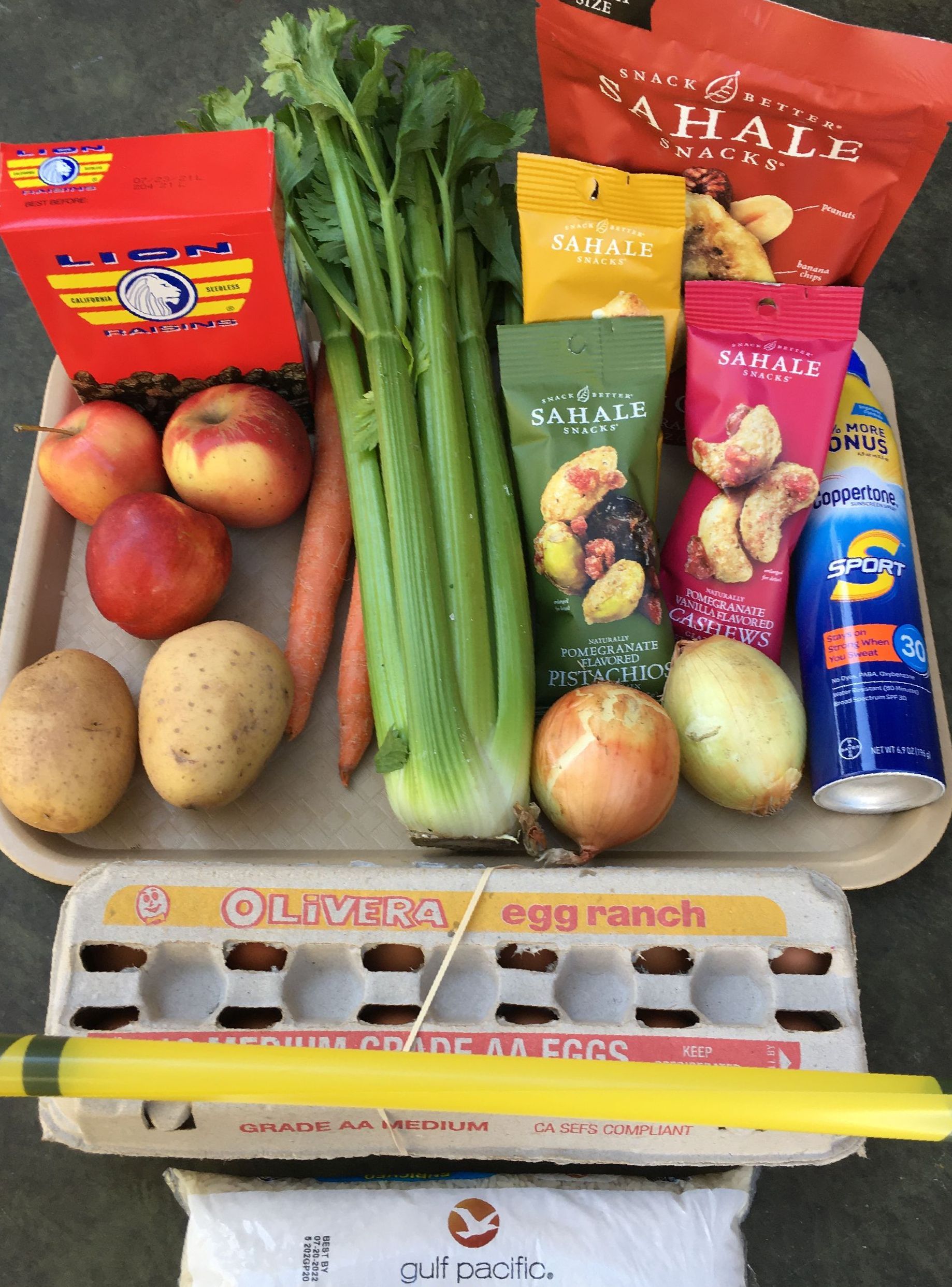 A tray of potatoes, celery, trail mix, carrots, apples, and other foods and items that are being served at one of our volunteer serving opportunities