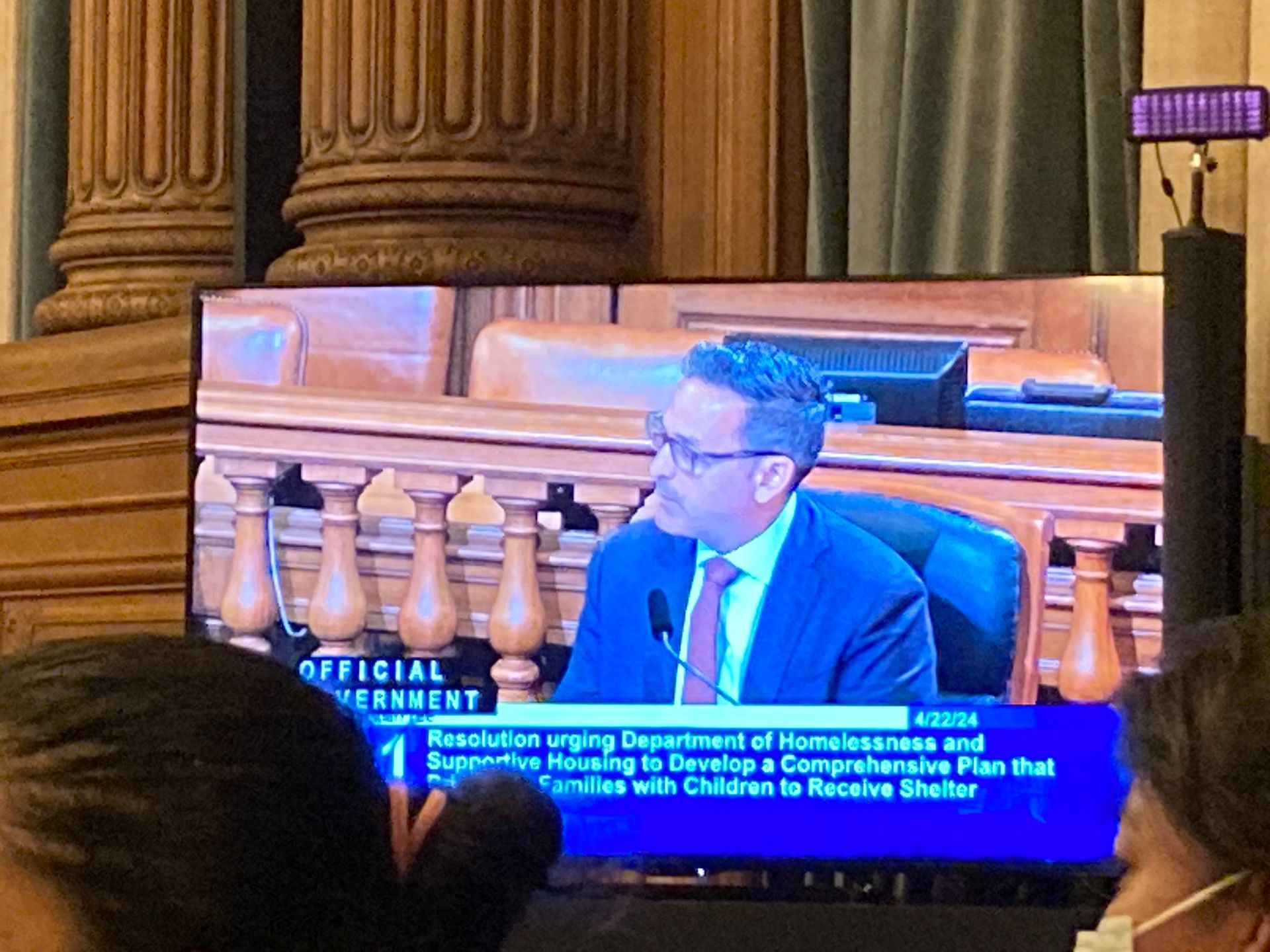 A picture of the TV monitor showing Ahsha Safai speaking to the Dept. of Homelessness urging to support housing to develop a comprehensive plan that shelters families with children. 