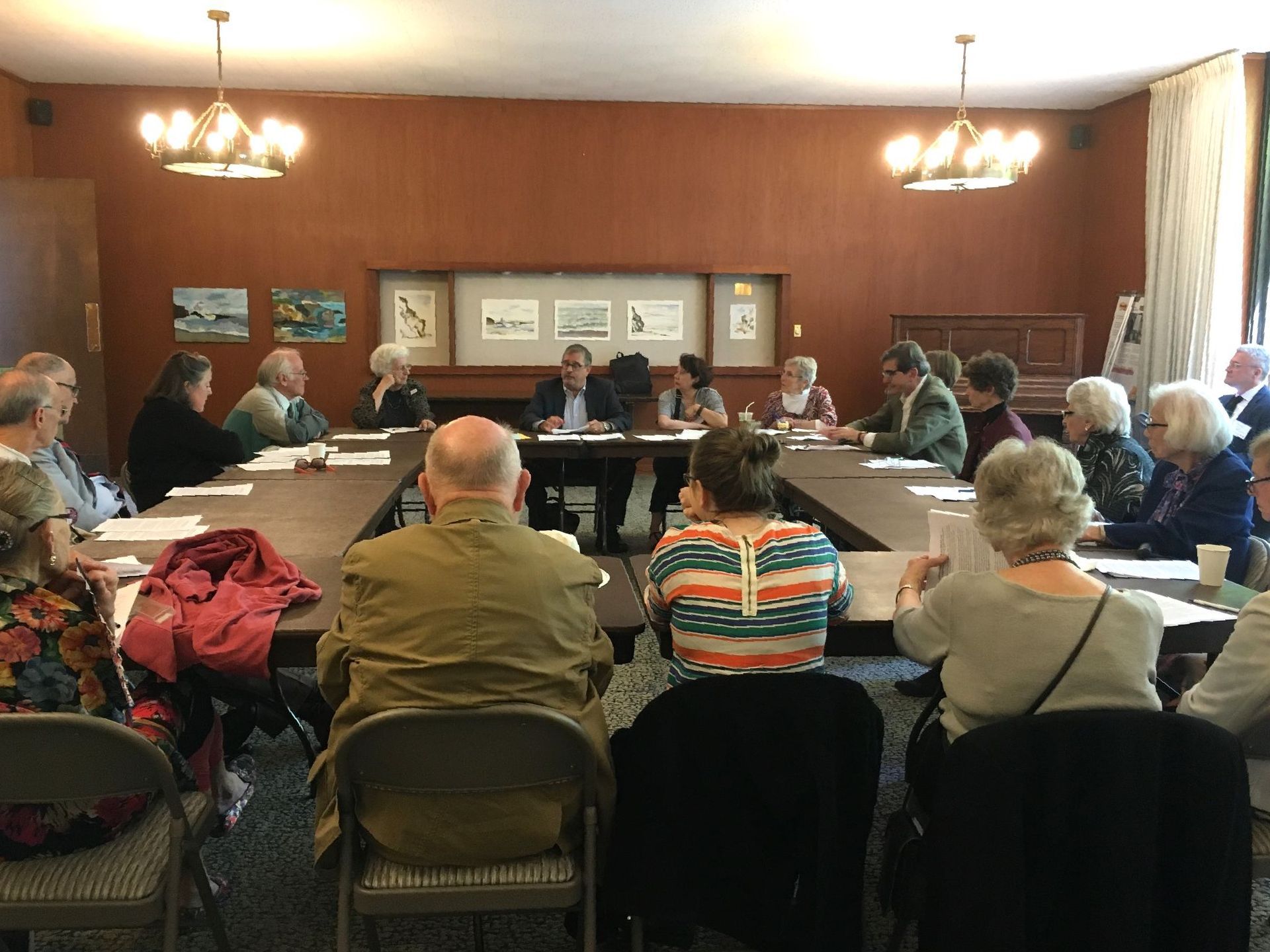 A group of Calvary goers sitting tables set up in a large conference style in the Lounge