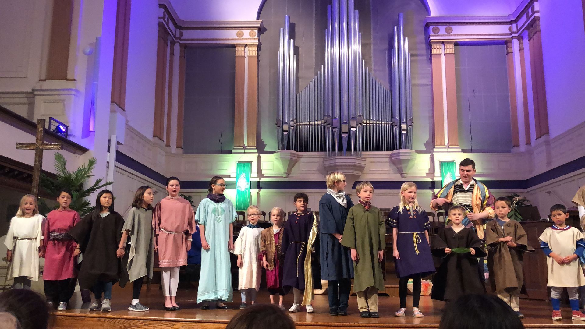 The children's choir in various robes on the Chancel in the Sanctuary during a performance