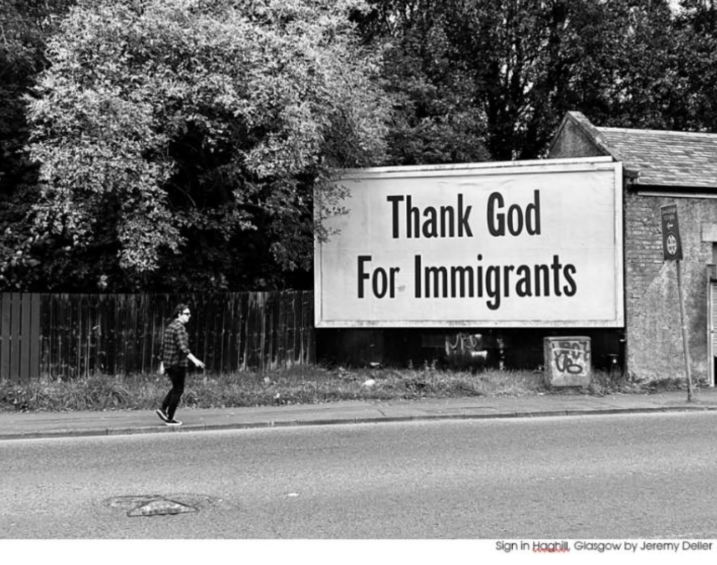 A black and white image of a billboard that reads 'thank god for immigrants'