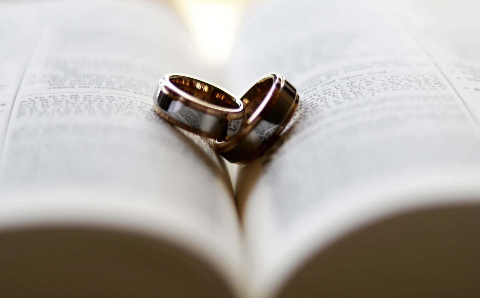 Two rings in a bible that are shaped like heart
