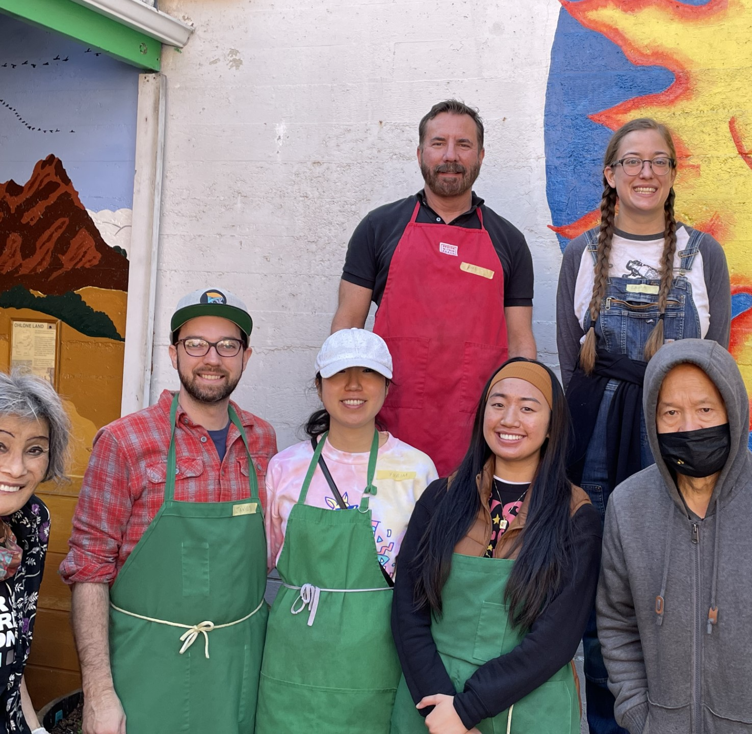 A group of volunteers standing outside of Martin de Porres Soup Kitchen in their aprons