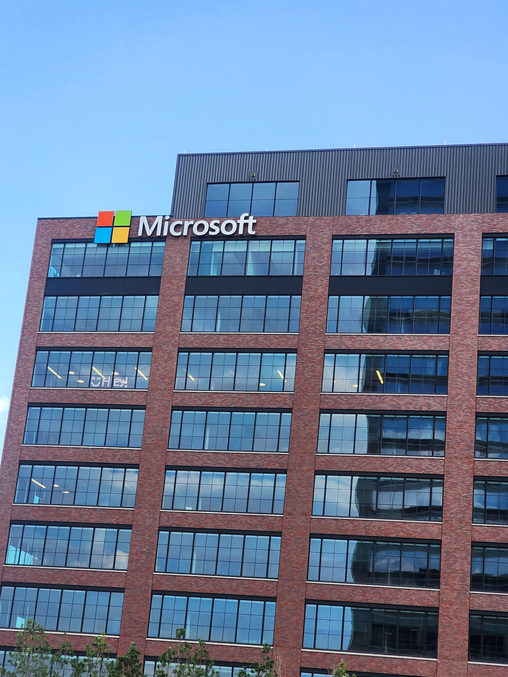 Microsoft building exterior with brick facade and logo under a blue sky.