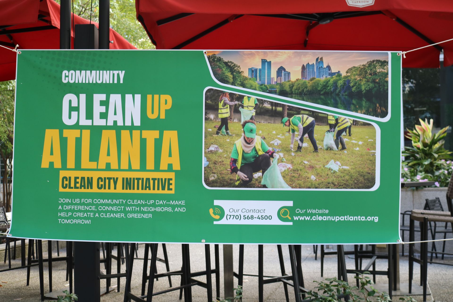 Banner for Atlanta clean-up initiative with volunteers picking up litter. Green, yellow, and white colors with city skyline.
