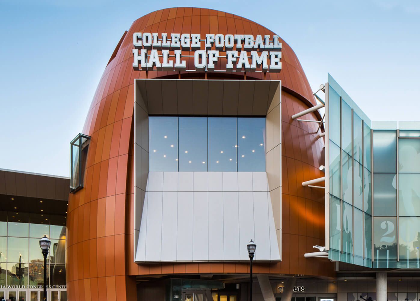 College Football Hall of Fame building in Atlanta; exterior view with orange facade shaped like a football.
