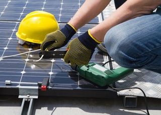 Solar Energy — Man Installing A Solar Panel in Hamburg, NY