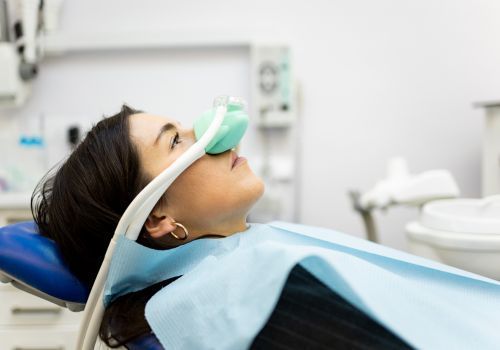Patient reclining in a dental chair with oxygen mask in a clinic