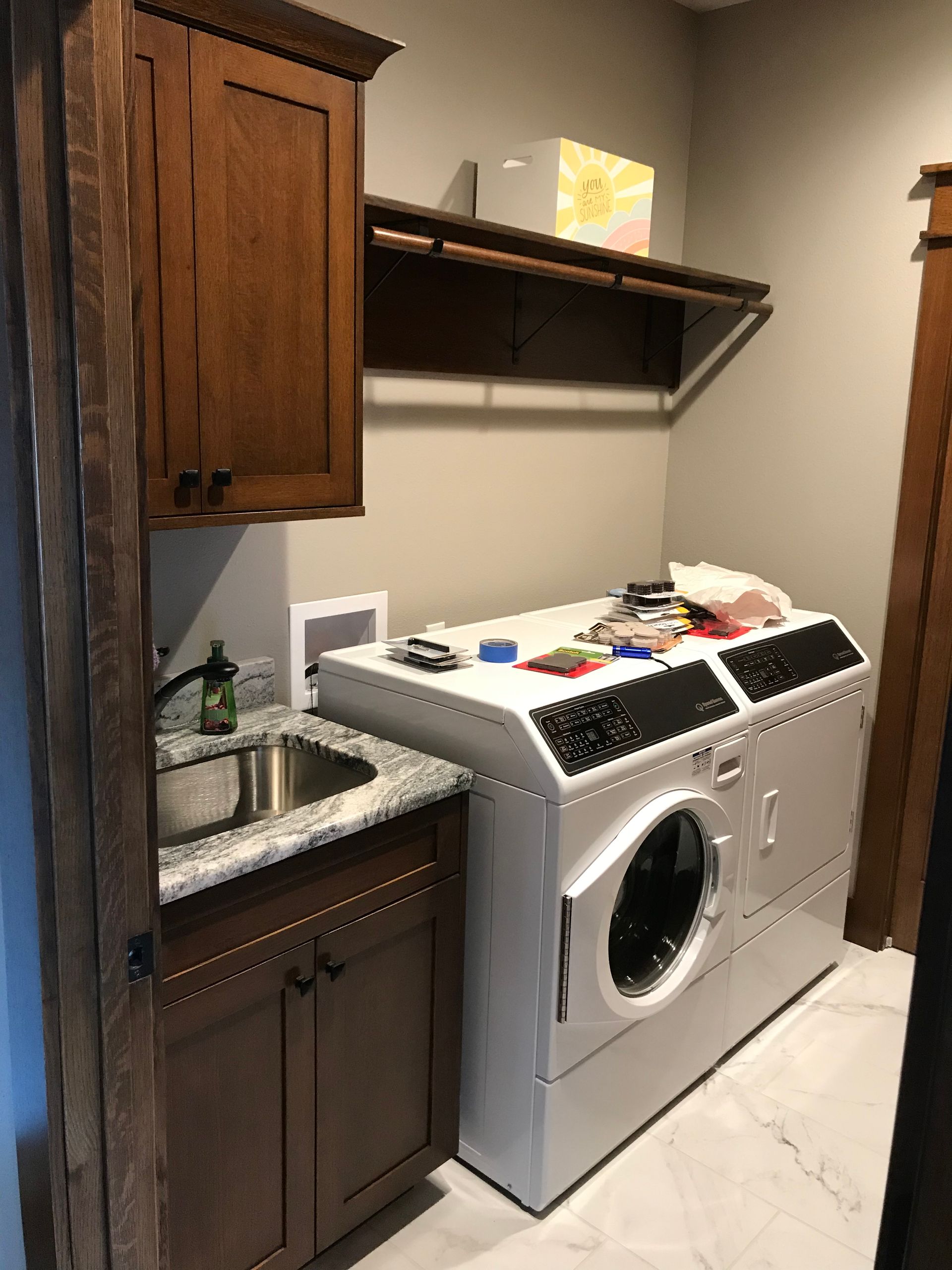 A laundry room with a washer and dryer and a sink.