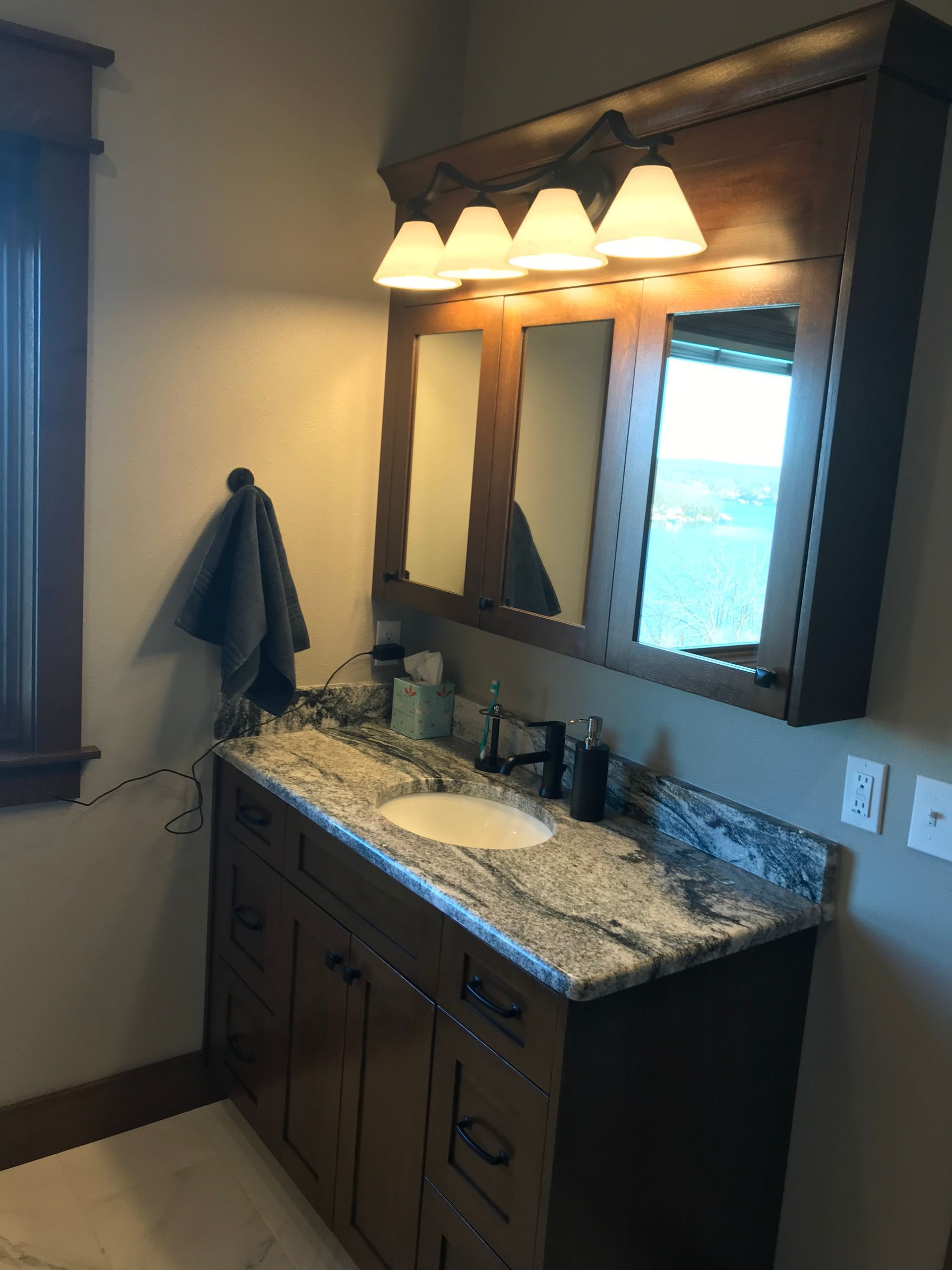 A bathroom with a sink and two mirrors