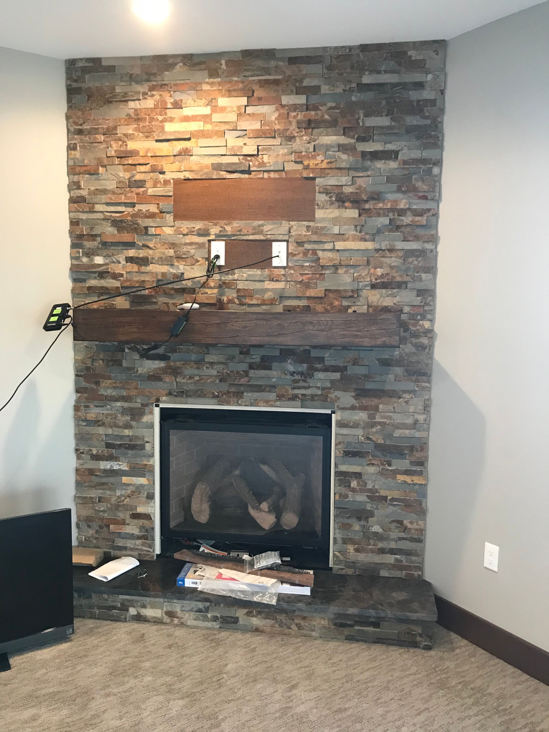 A living room with a fireplace and a brick wall