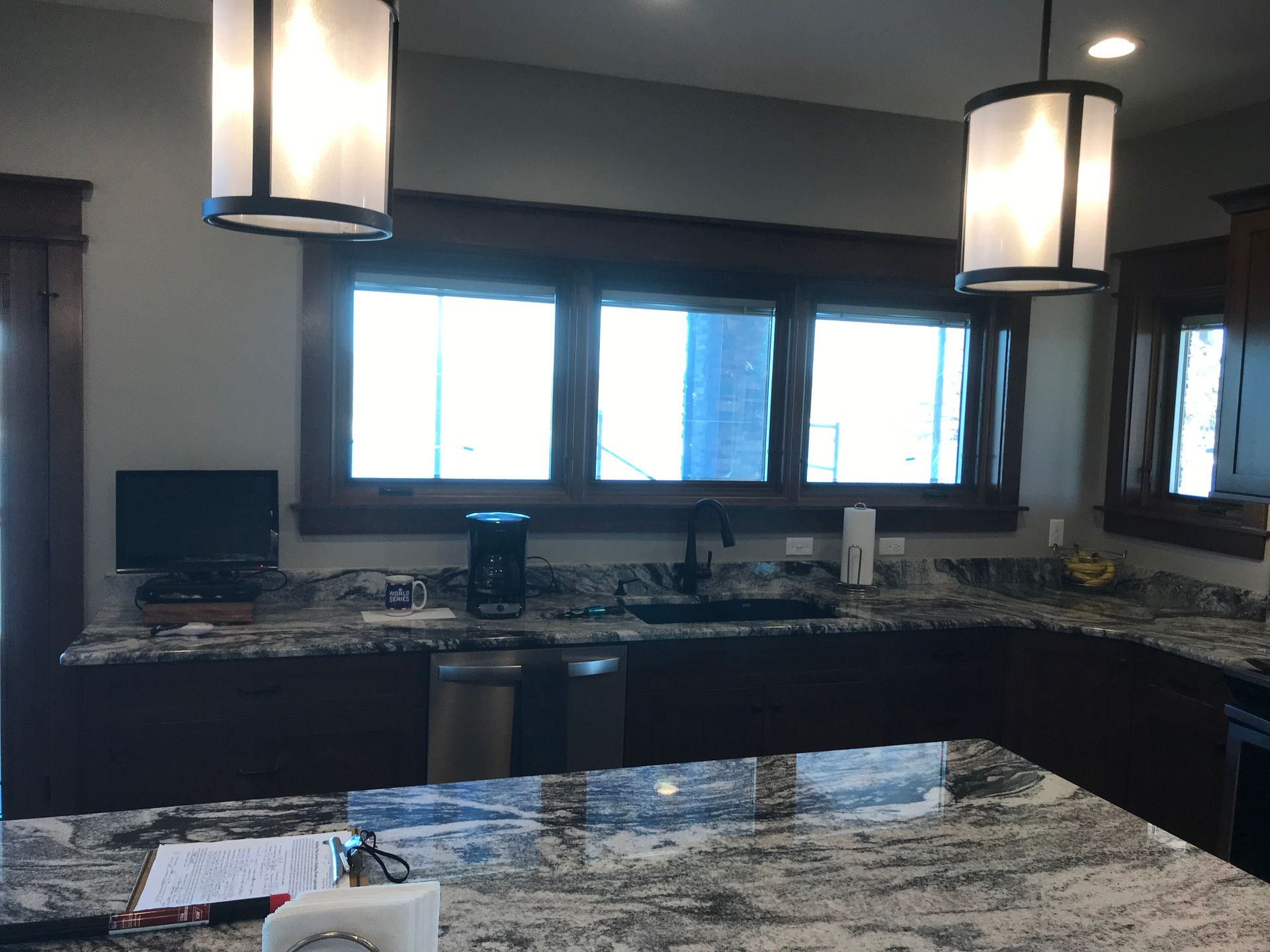 A kitchen with granite counter tops and a computer on the counter