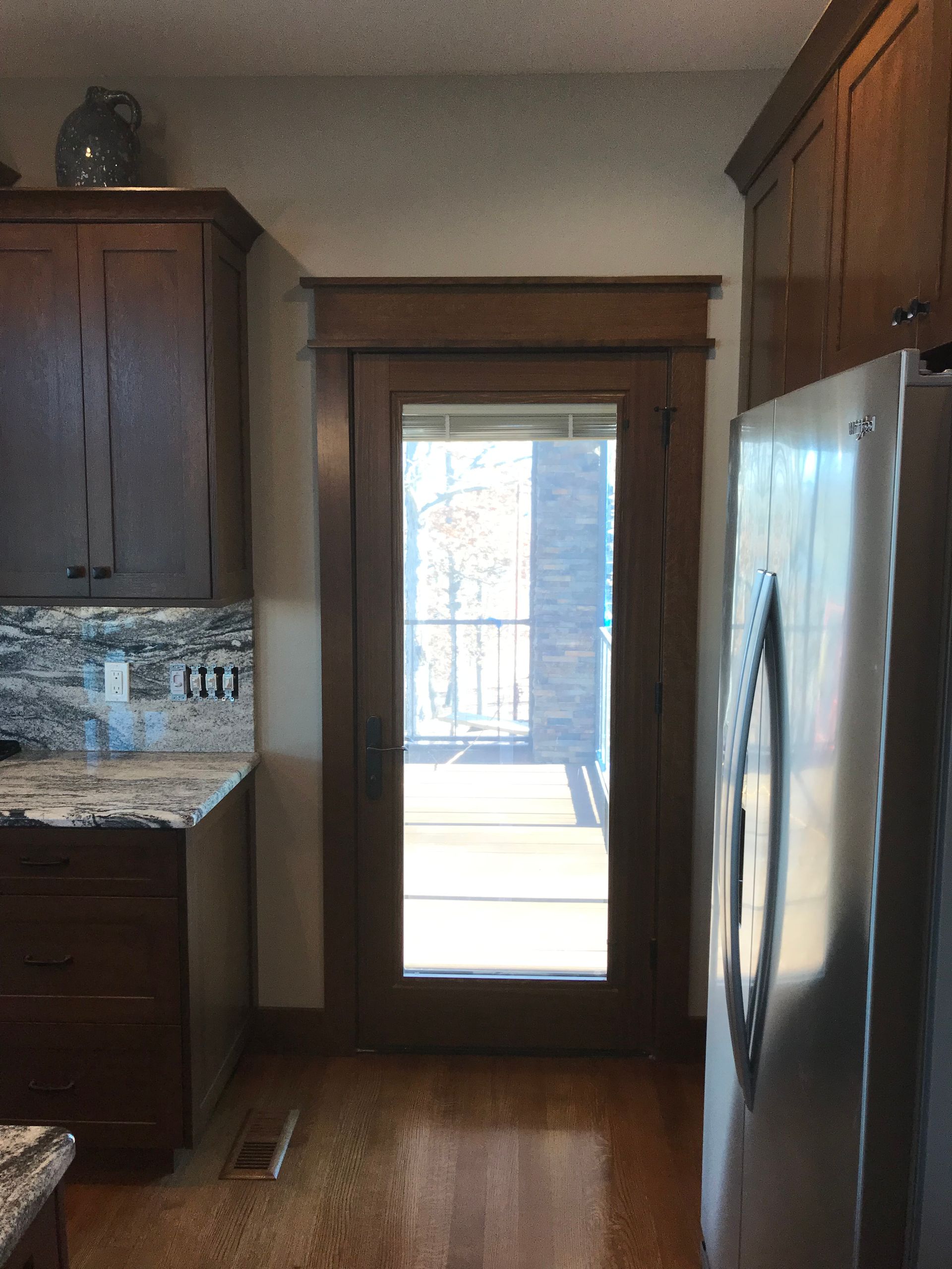 A kitchen with a stainless steel refrigerator and a glass door