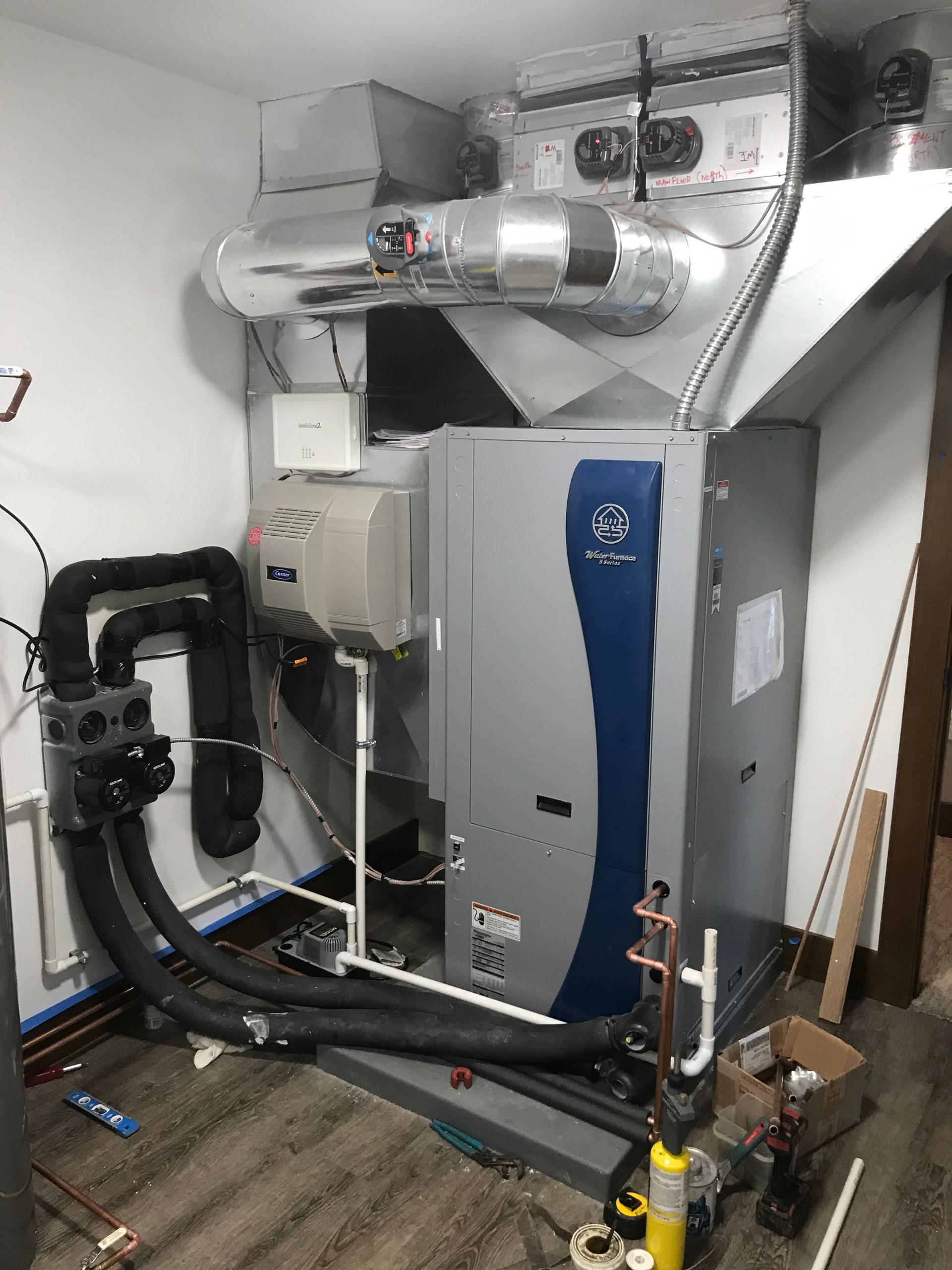 A large gray and blue heater is sitting in a room.