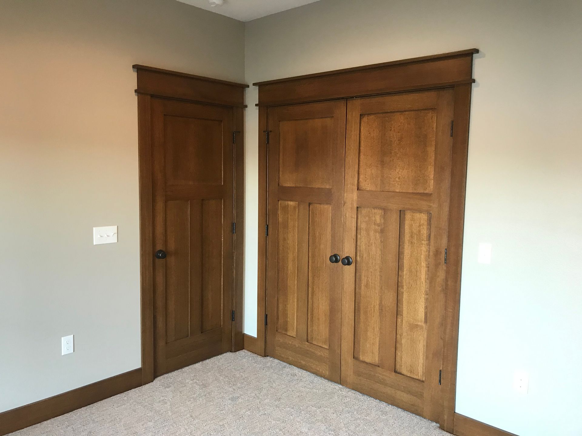 There are two wooden doors in the corner of the room.