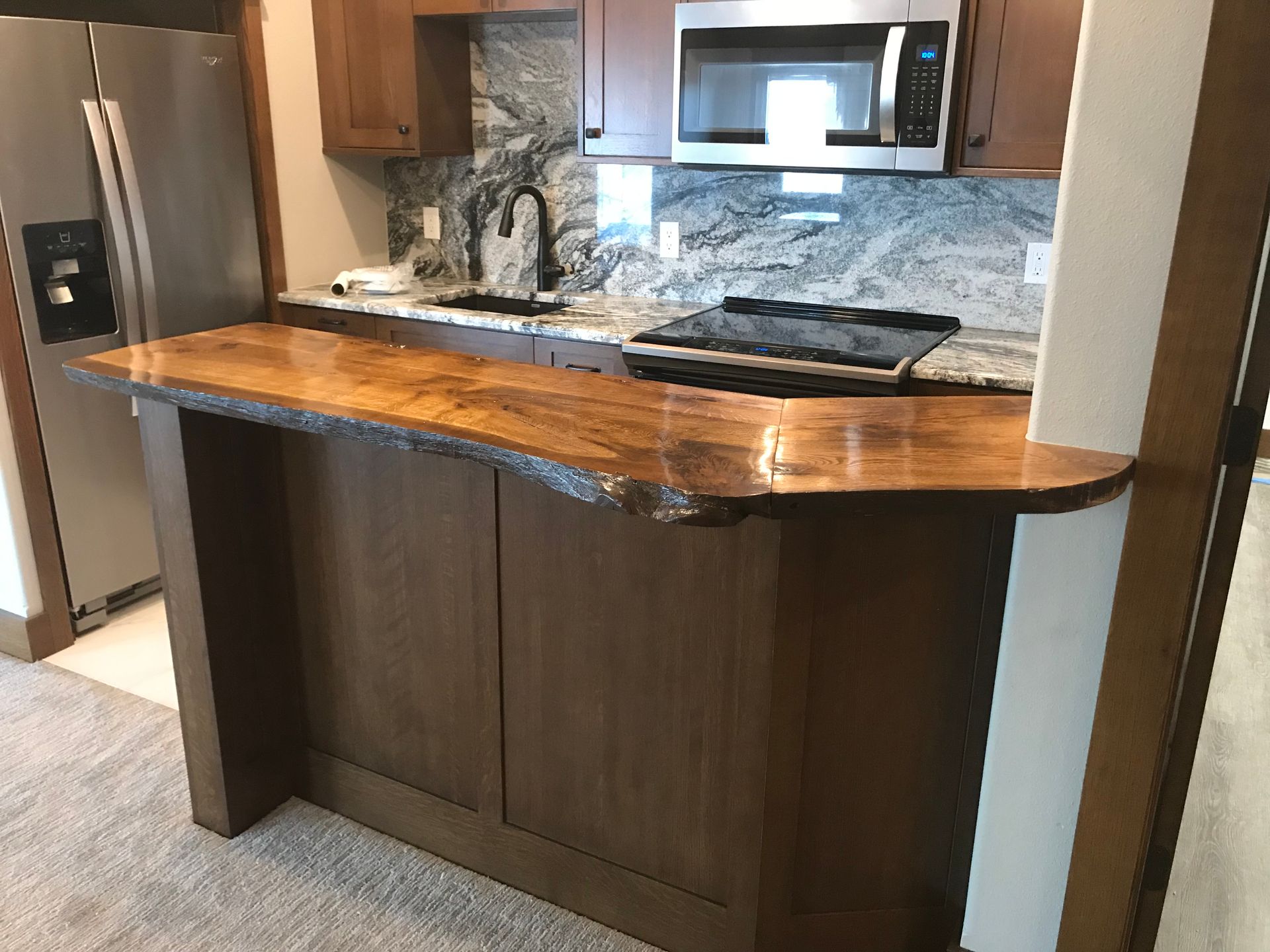 A kitchen with stainless steel appliances and a wooden counter top.