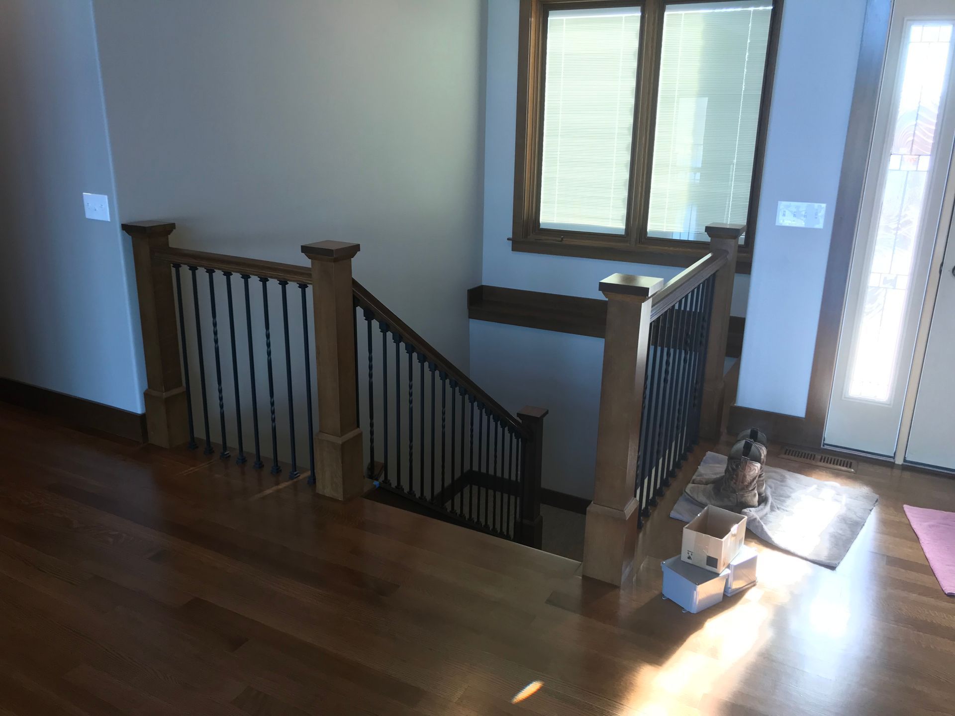 A wooden staircase with a metal railing and a window in a house.