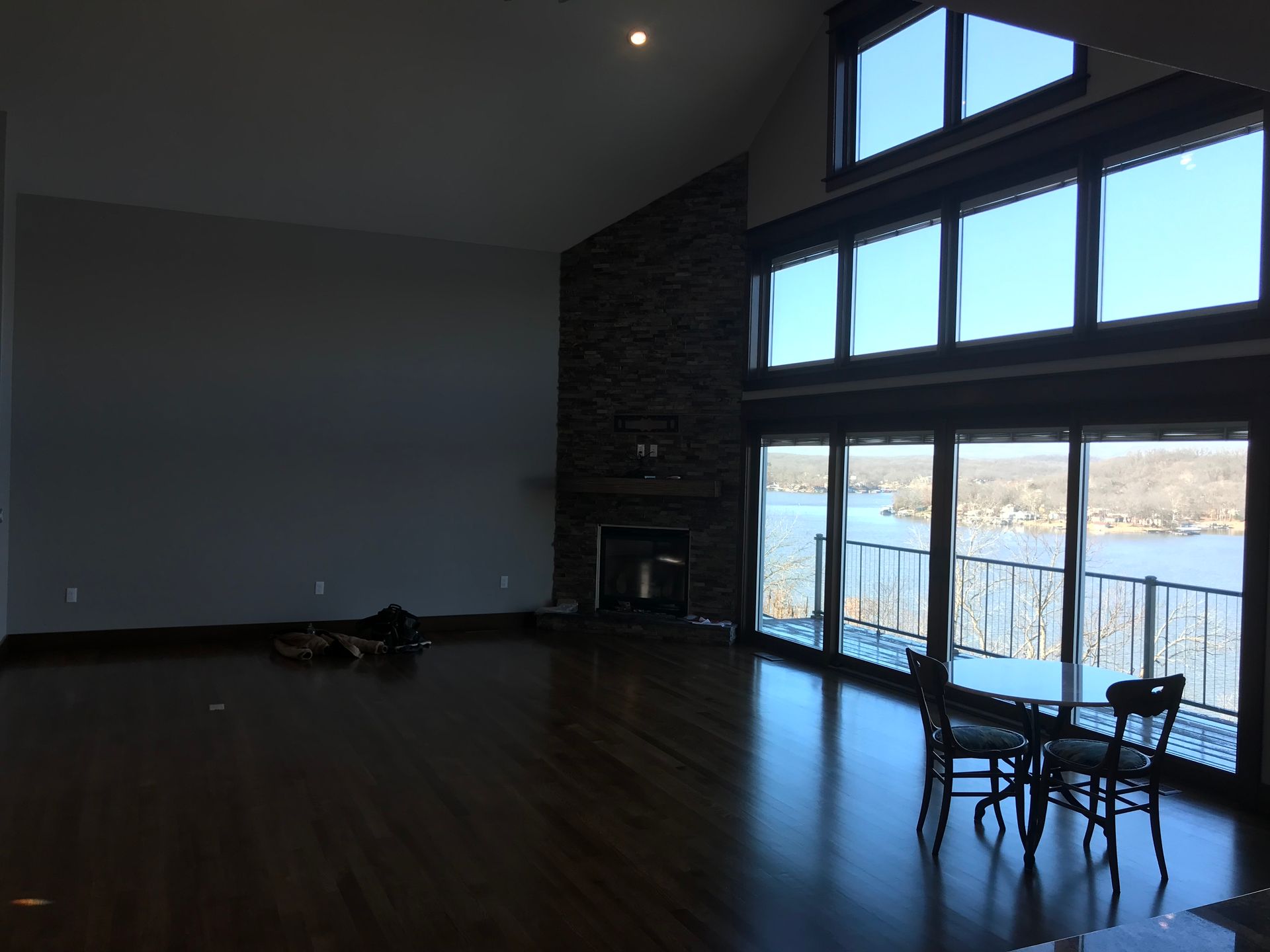 An empty living room with a table and chairs and a fireplace
