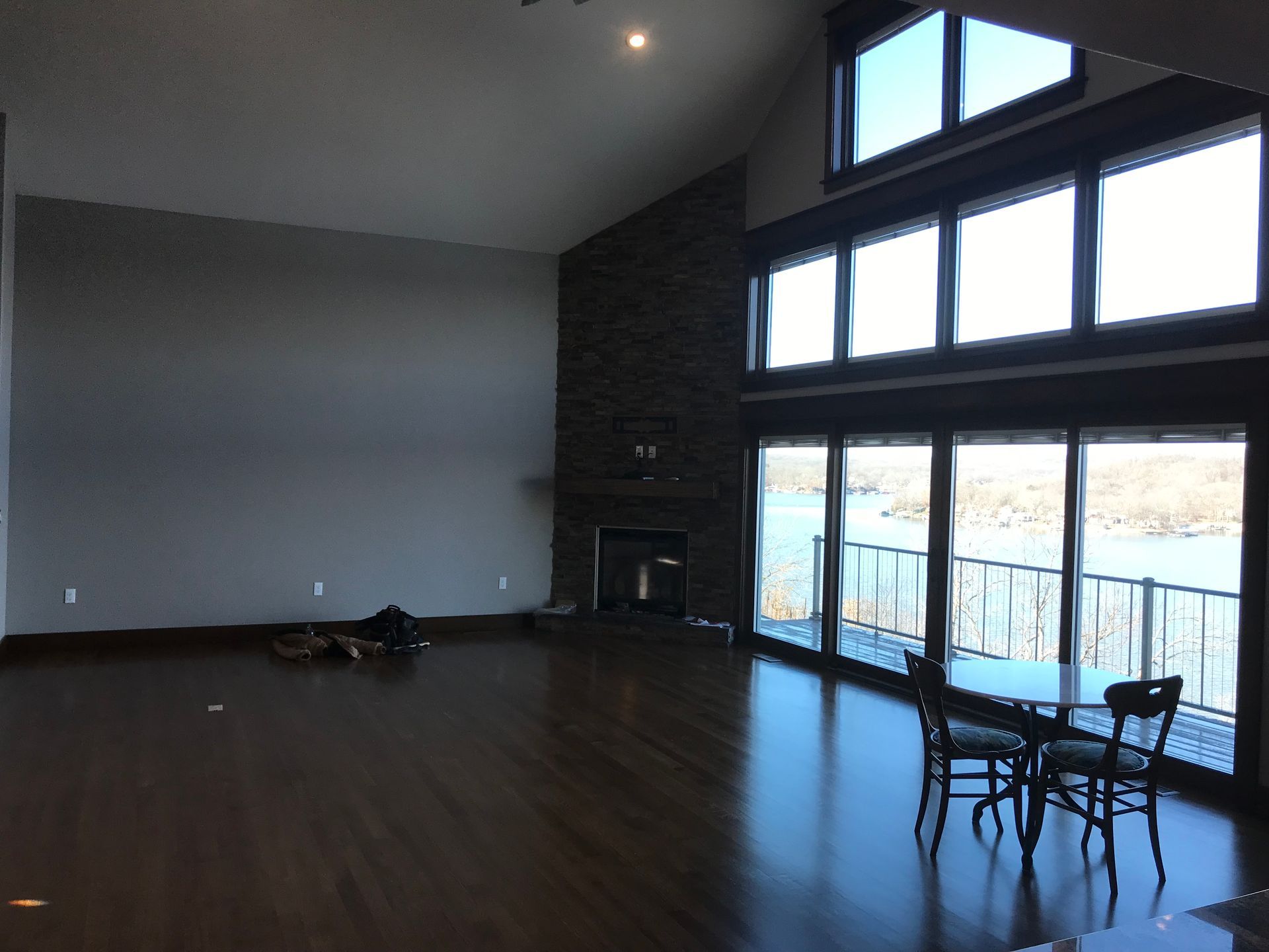 An empty living room with a table and chairs and a fireplace