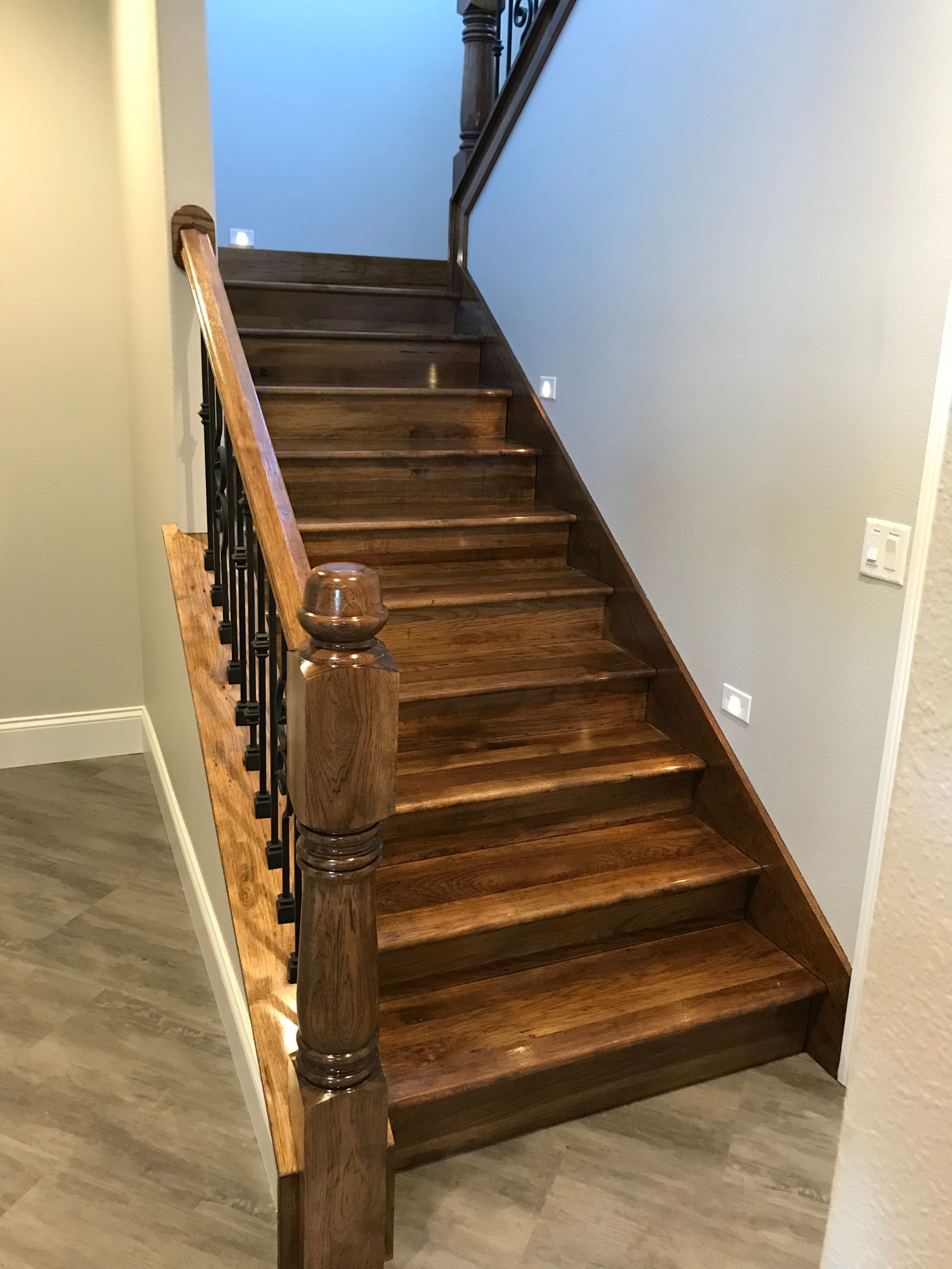 A wooden staircase with a metal railing in a house.
