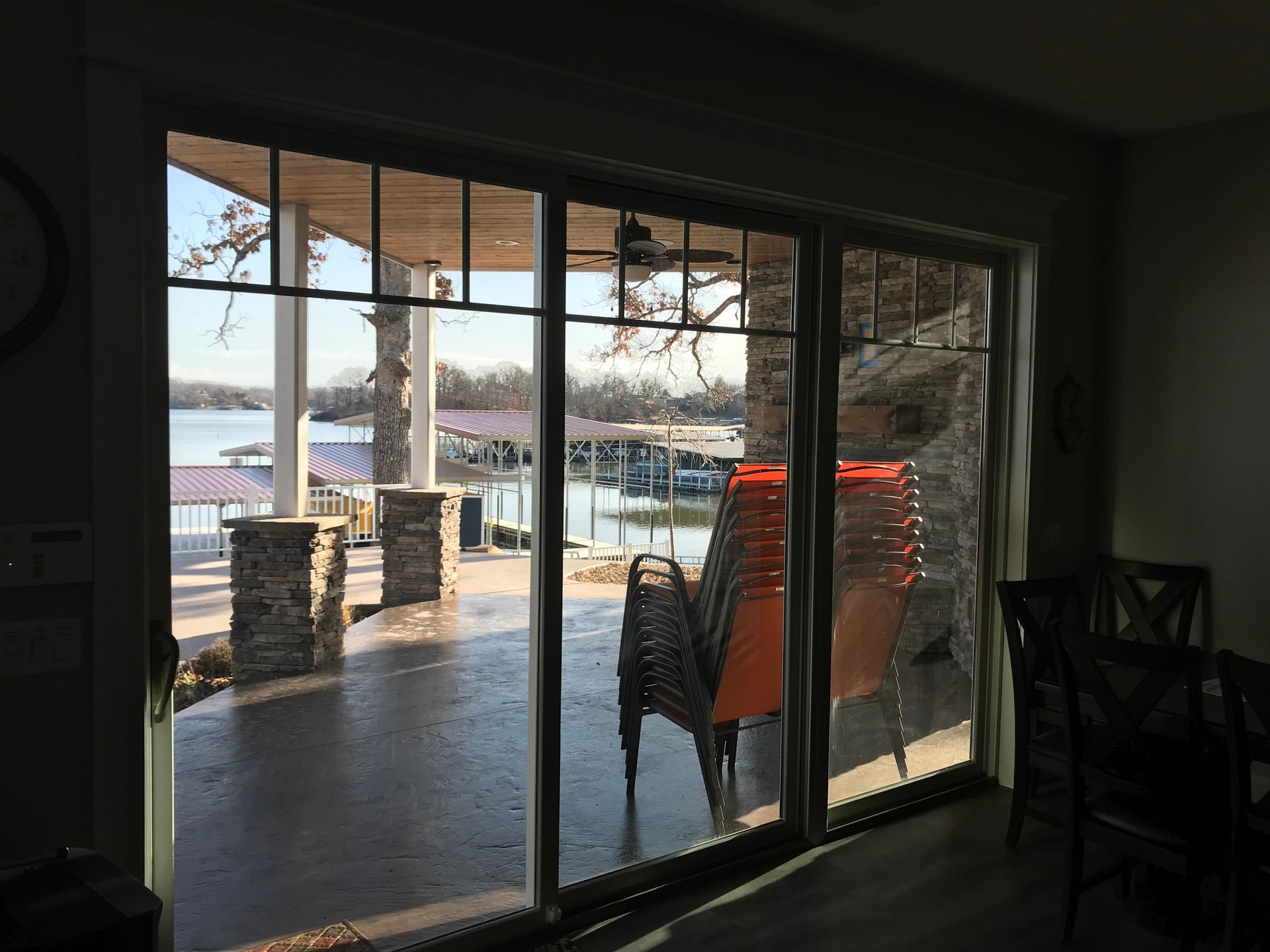 A room with a view of a lake through a sliding glass door.
