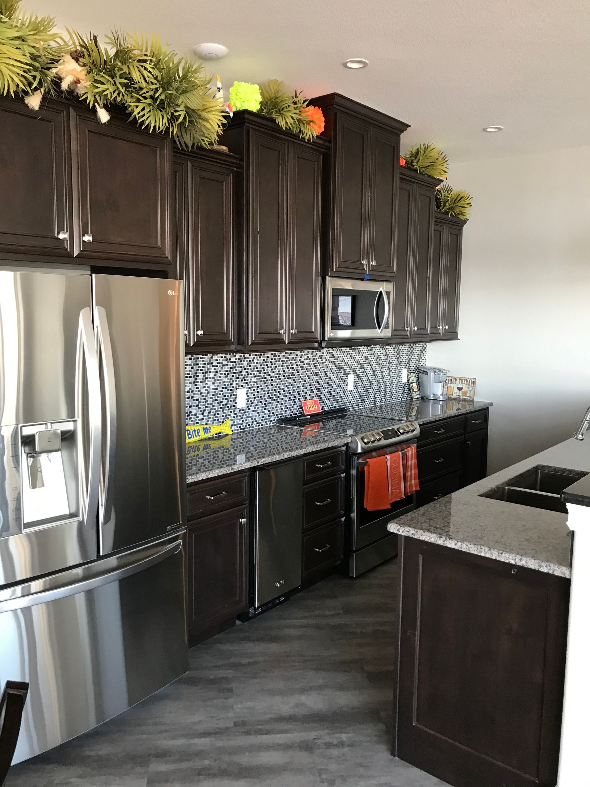 A kitchen with stainless steel appliances and brown cabinets