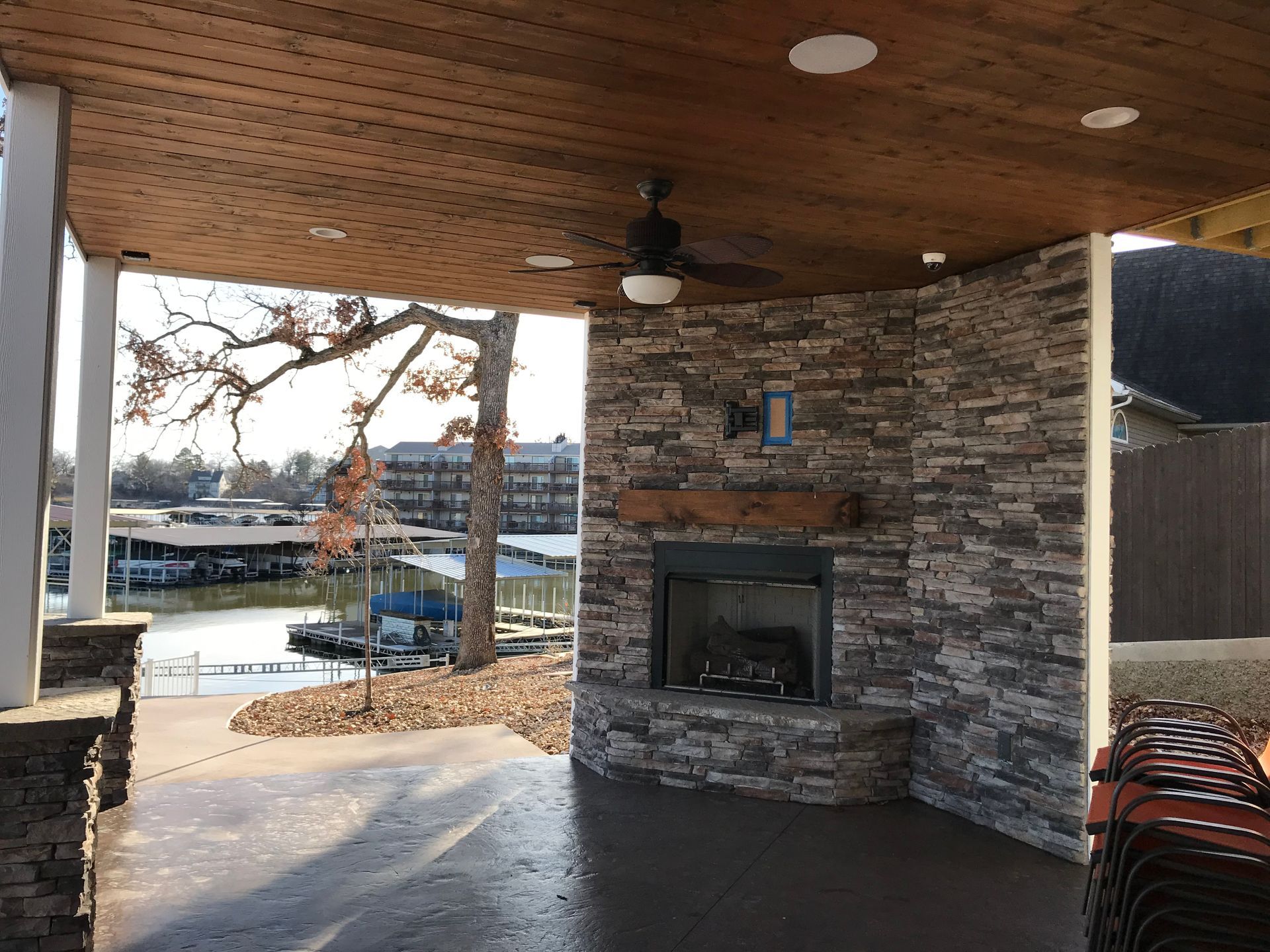 There is a fireplace in the middle of the room with a ceiling fan.