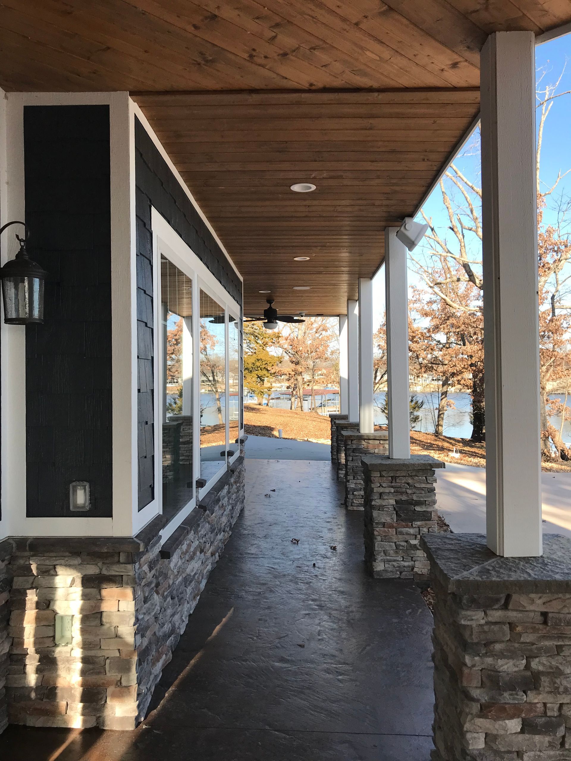 A porch with a ceiling fan and a view of a lake