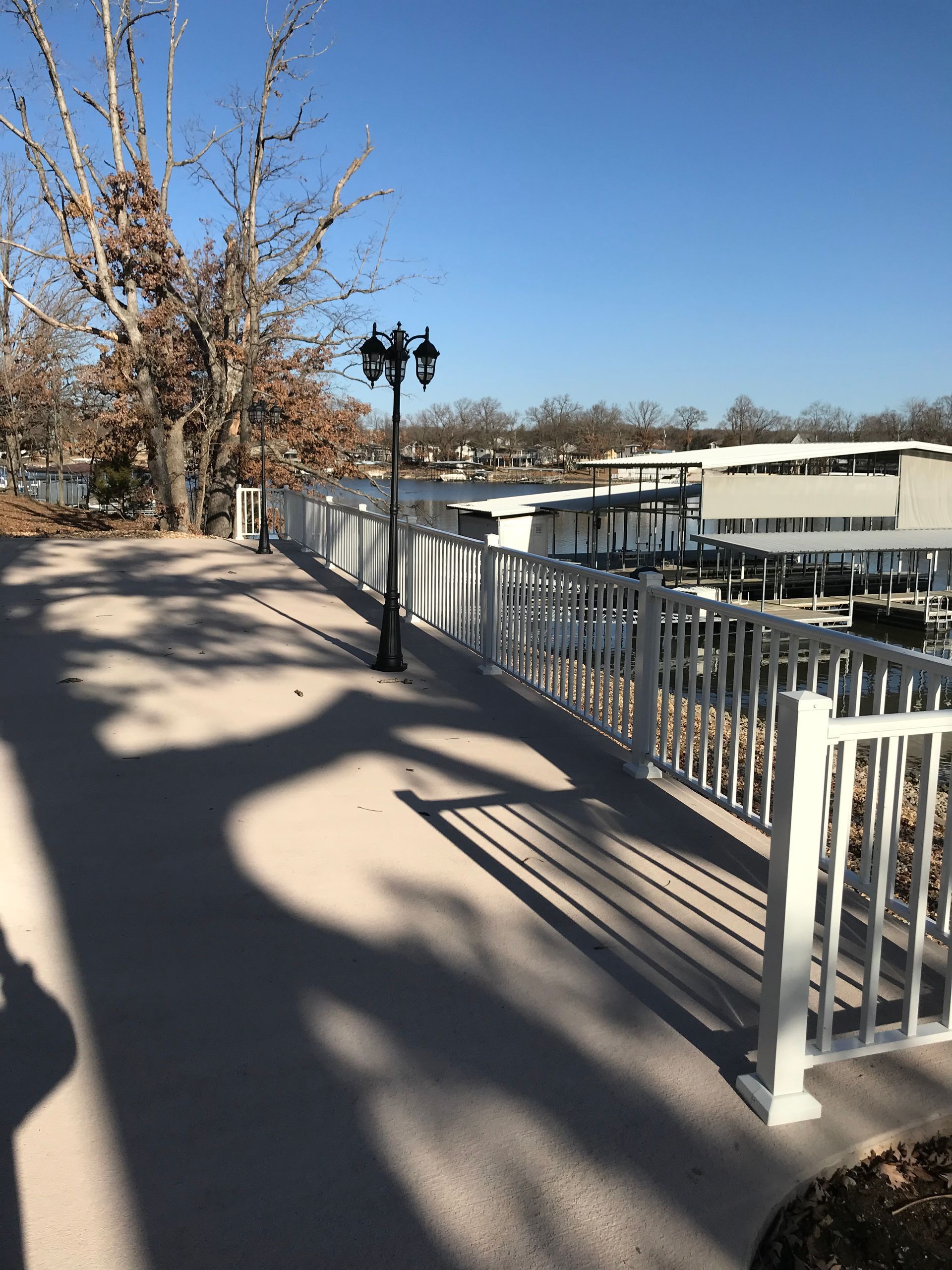 A walkway with a white railing and a lamp post
