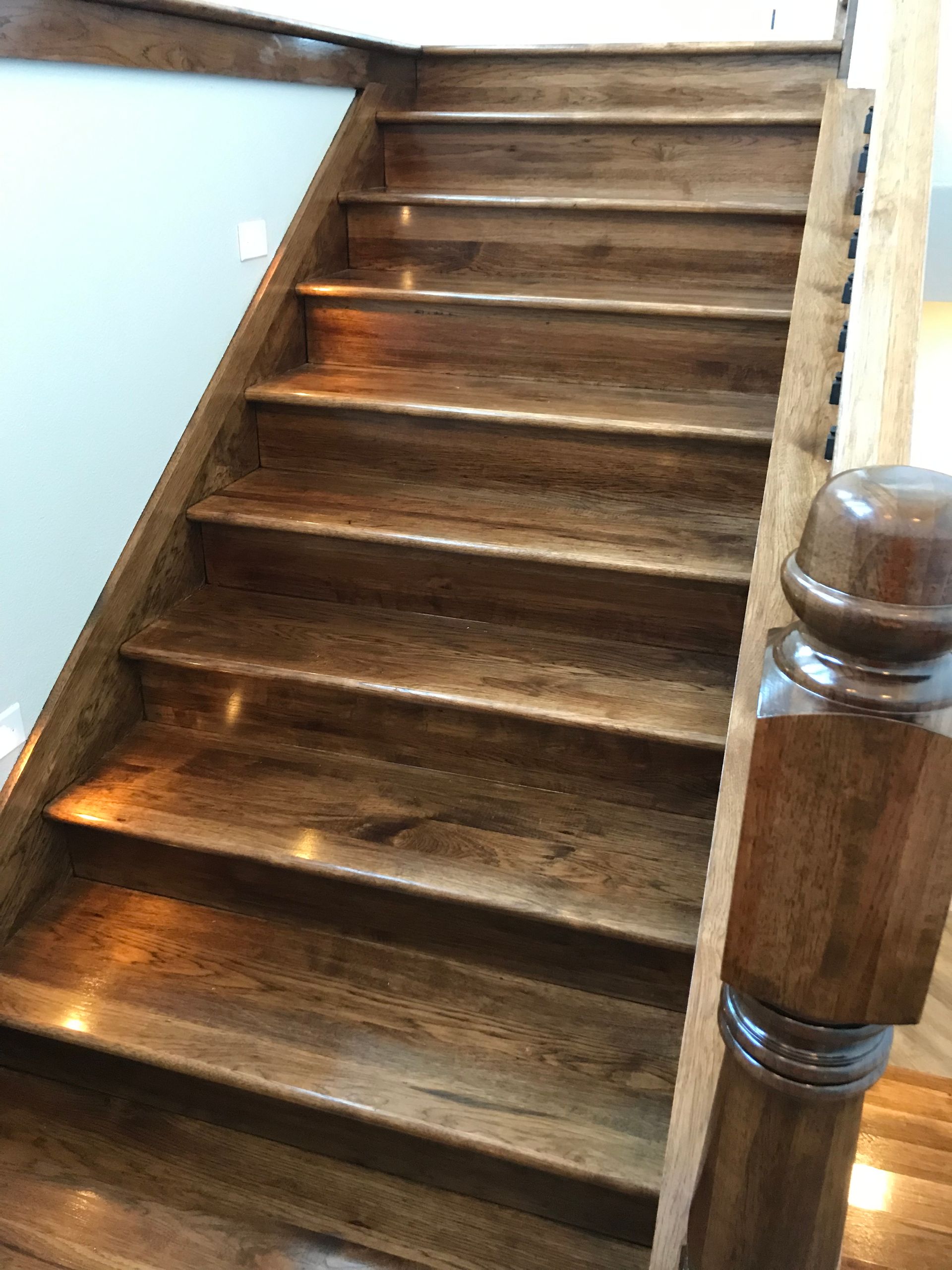 A wooden staircase with a wooden railing in a house.