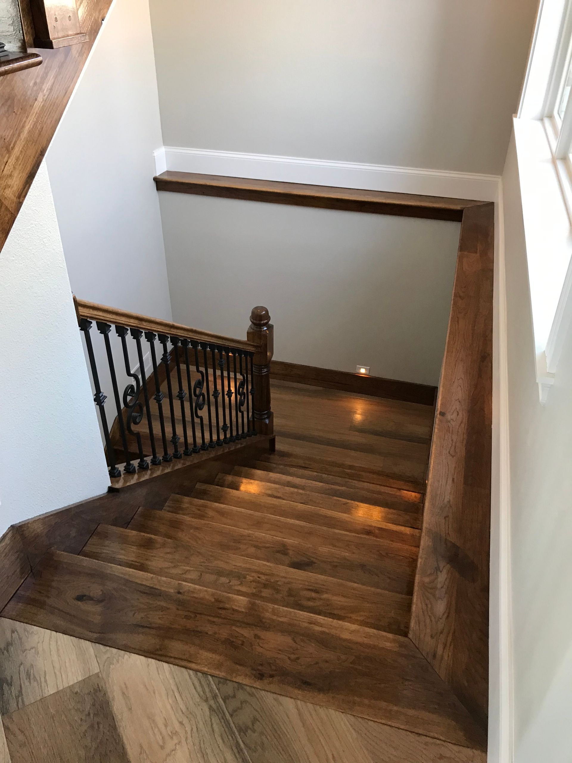 A wooden staircase with a metal railing in a house.
