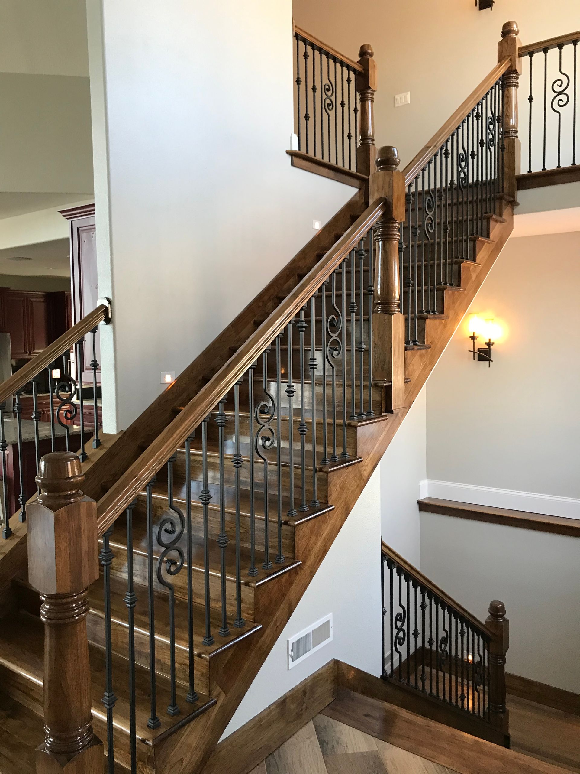 A wooden staircase with a wrought iron railing in a house