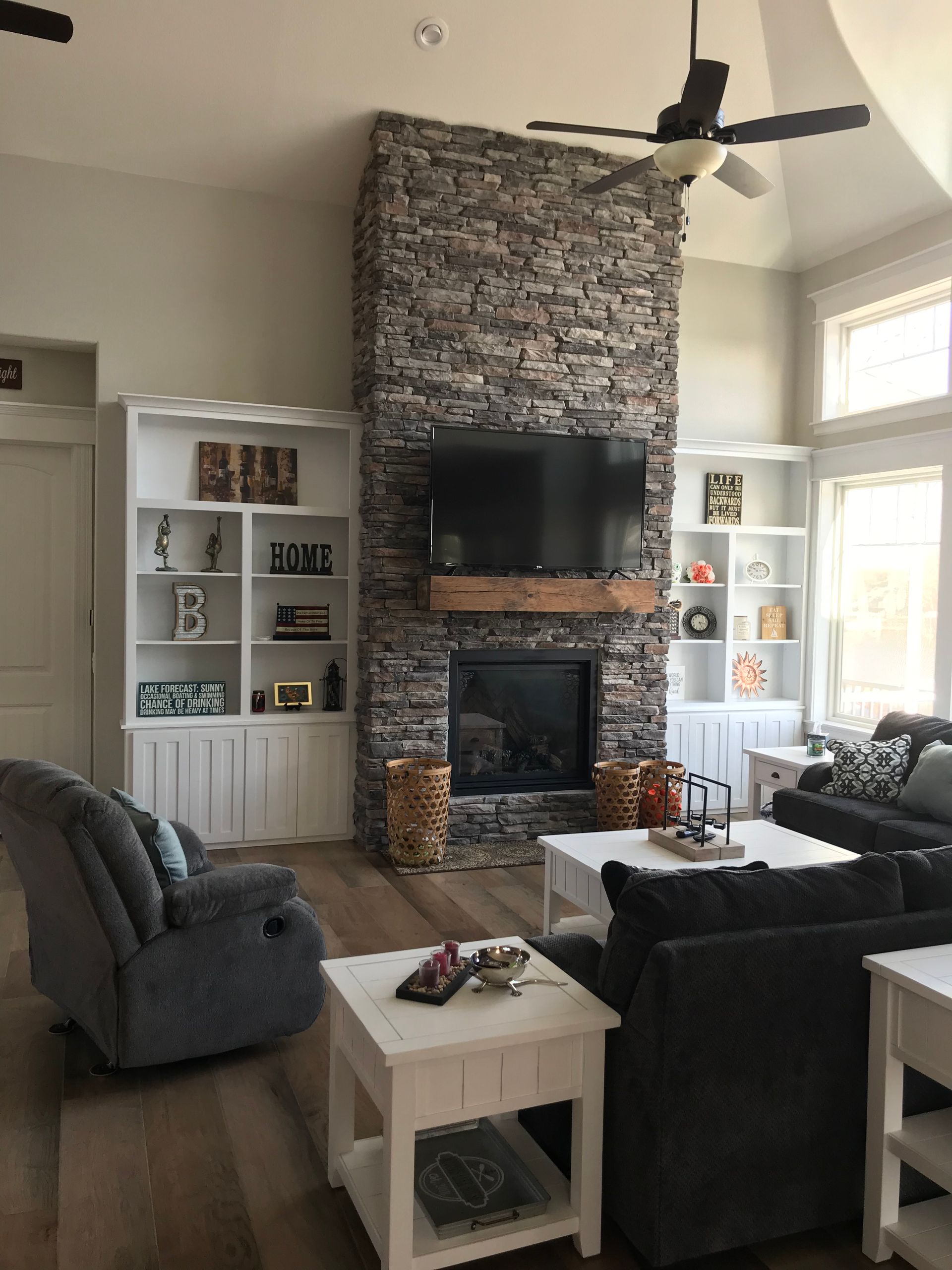 A living room with a fireplace and a flat screen tv on the wall.