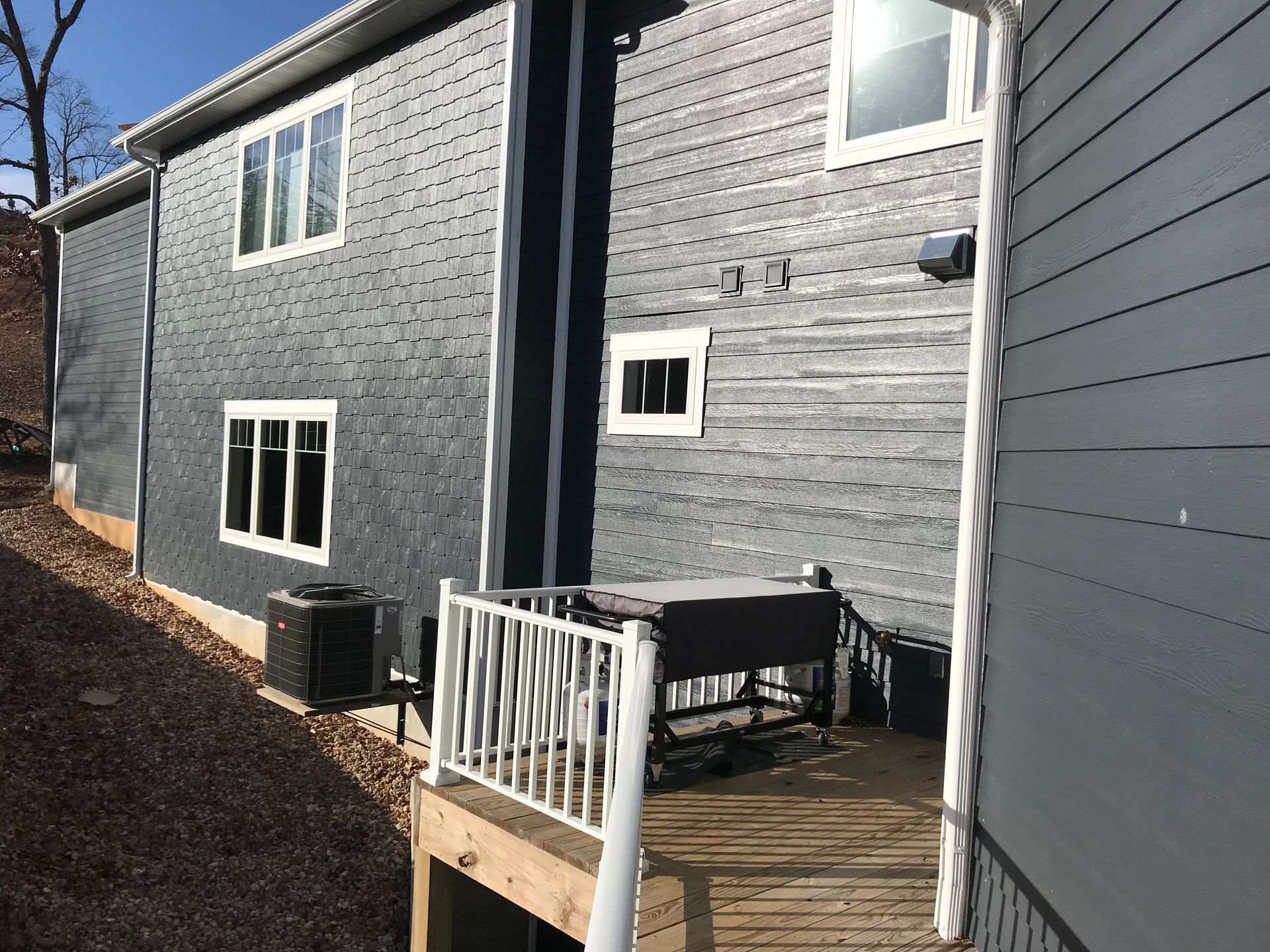 The back of a house with a deck and a hot tub.