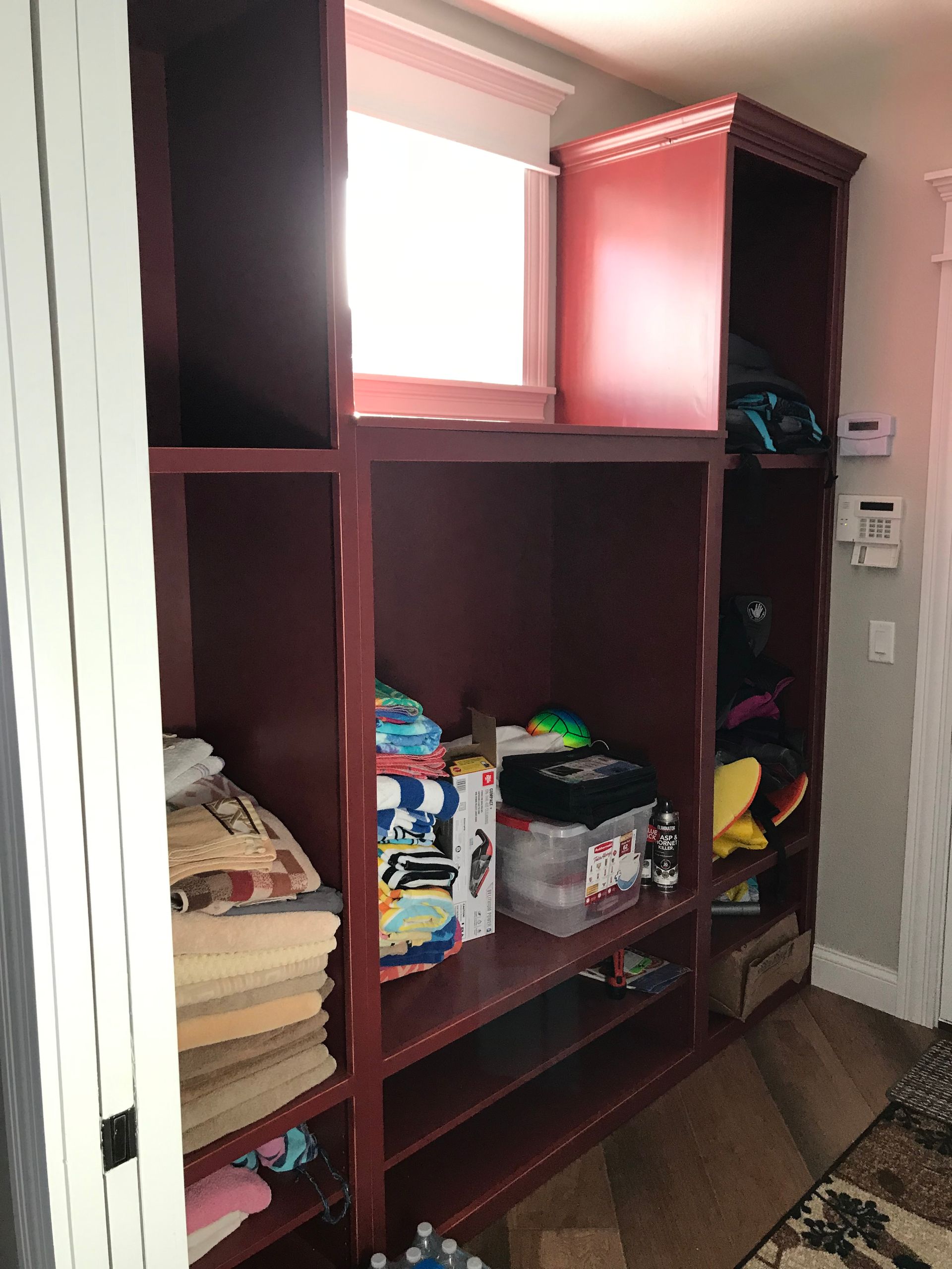 A room with a lot of shelves and a window