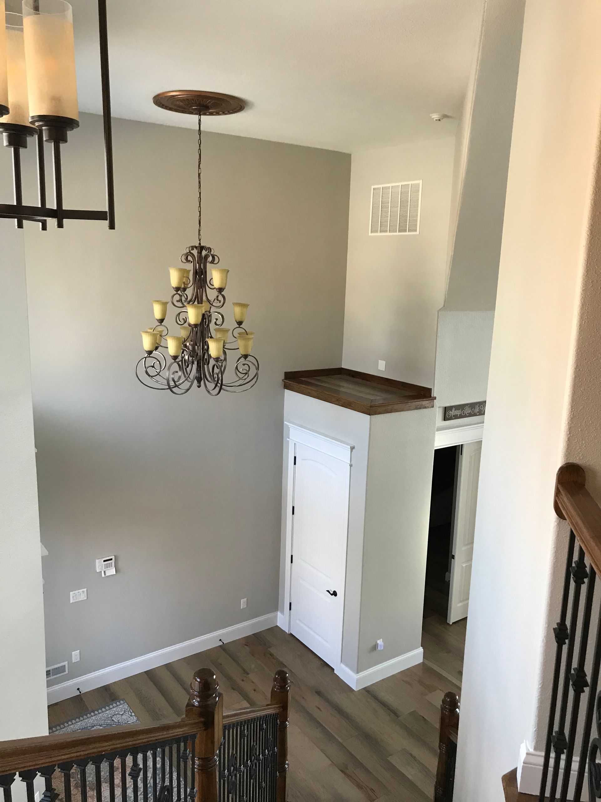 There is a chandelier hanging from the ceiling in the middle of the room.