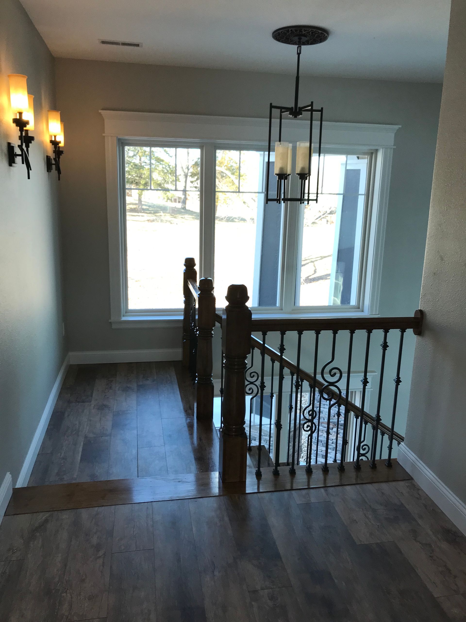 An empty hallway with a staircase and a window