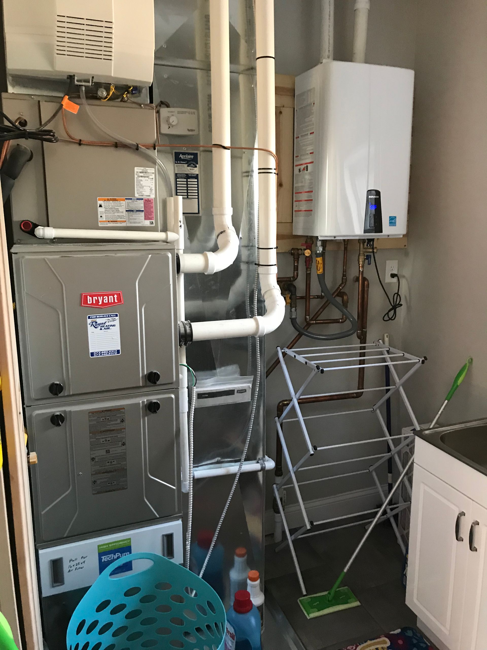 A laundry room with a stove and a drying rack