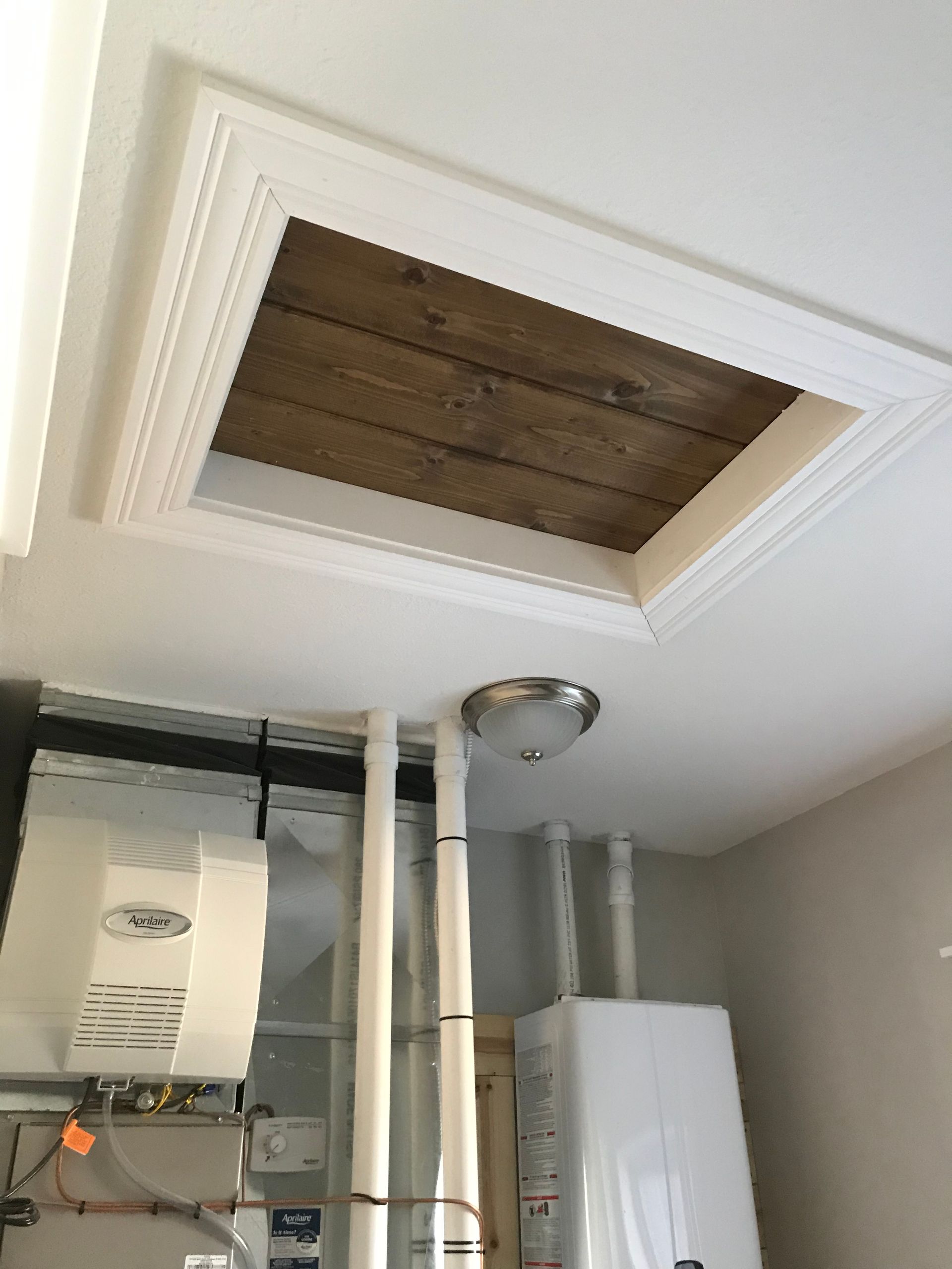 A room with a heater and a window in the ceiling