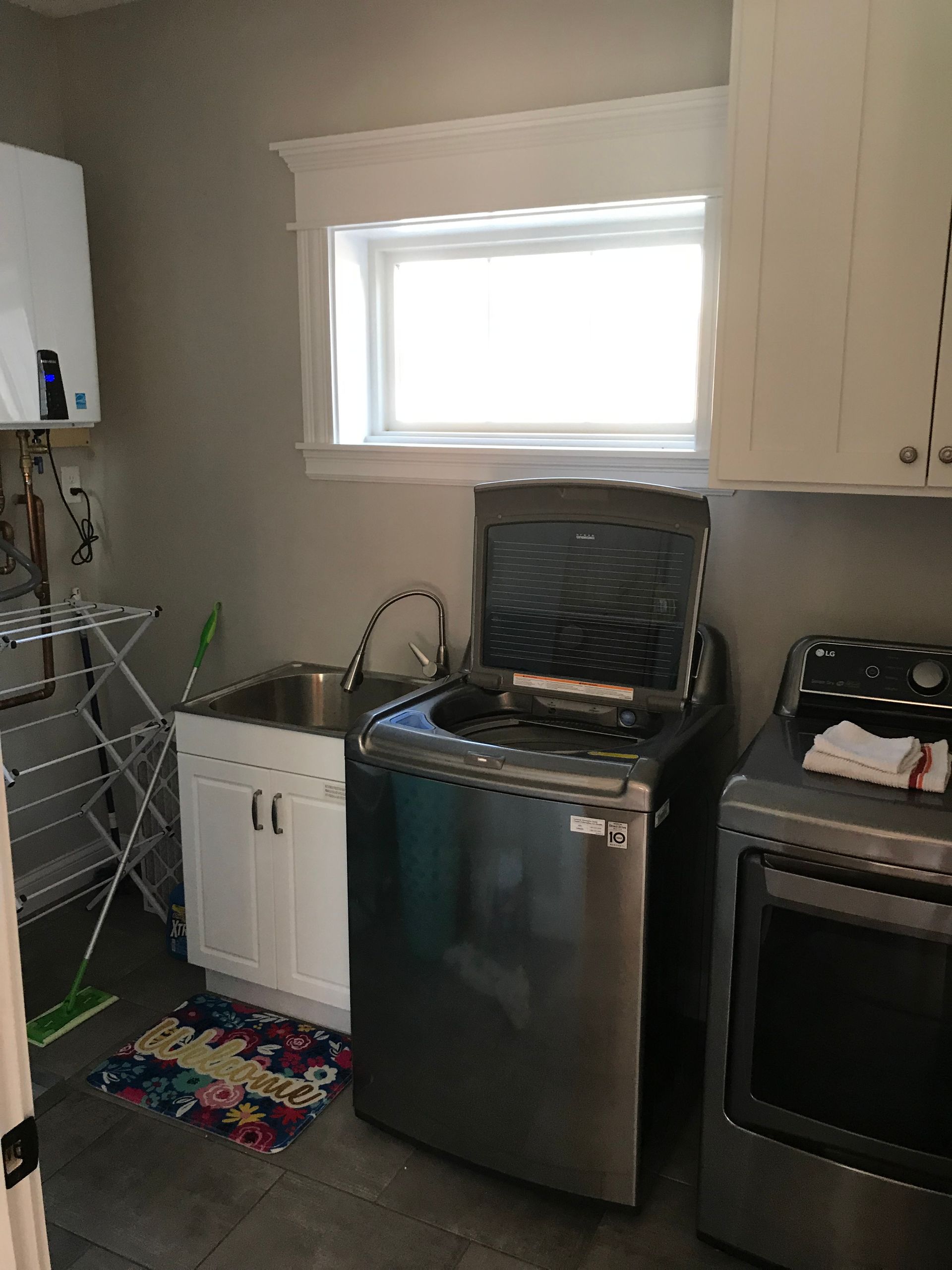 A laundry room with a washer and dryer and a sink.