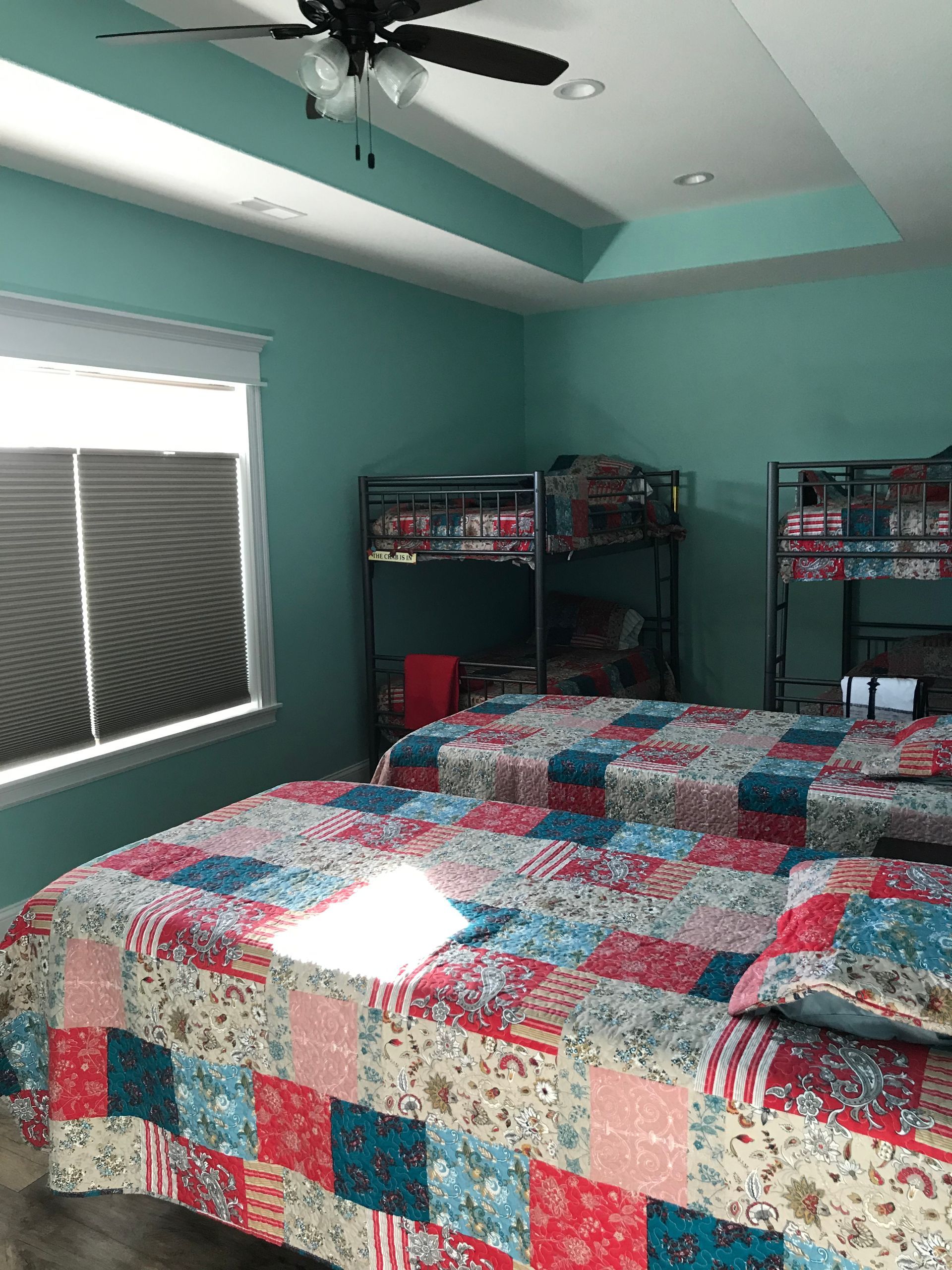 A bedroom with two beds and a bunk bed.