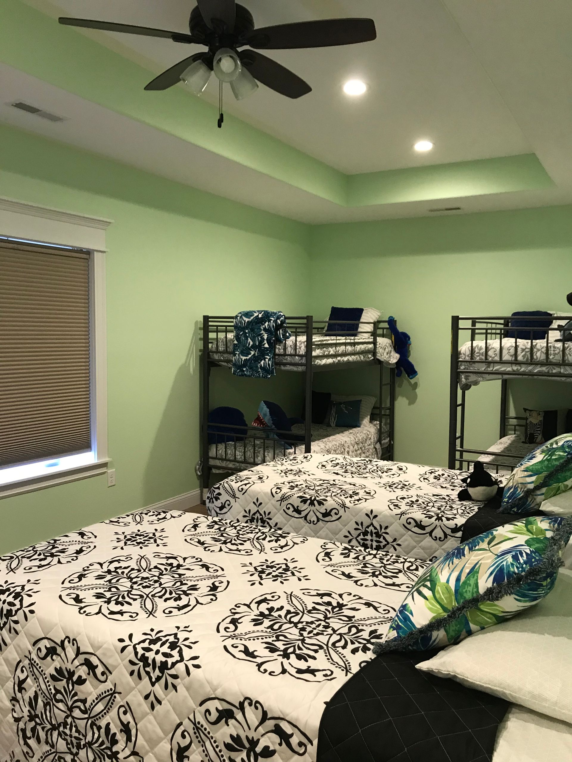 A bedroom with two bunk beds and a ceiling fan