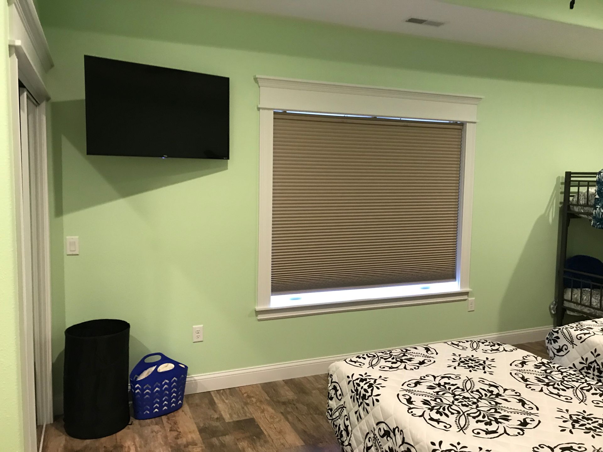 A bedroom with two beds , a television , and a window.
