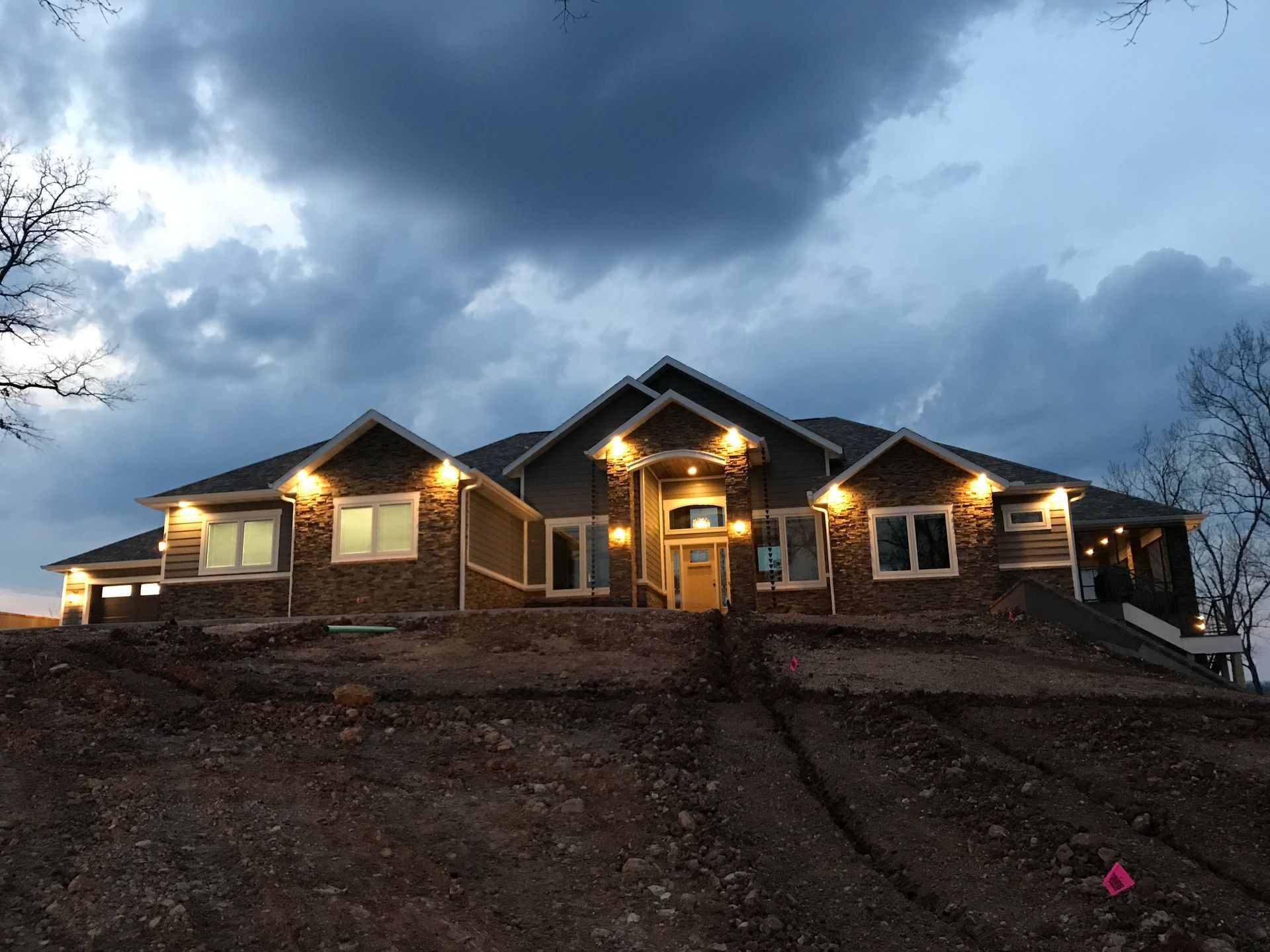 A large house is sitting on top of a hill at night.