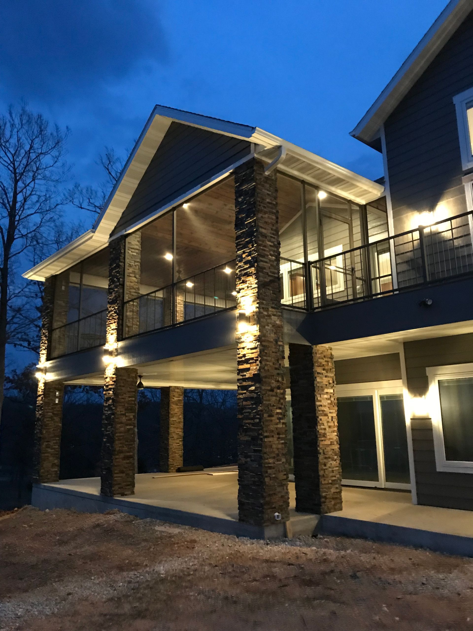 A large house with a lot of windows and a balcony at night