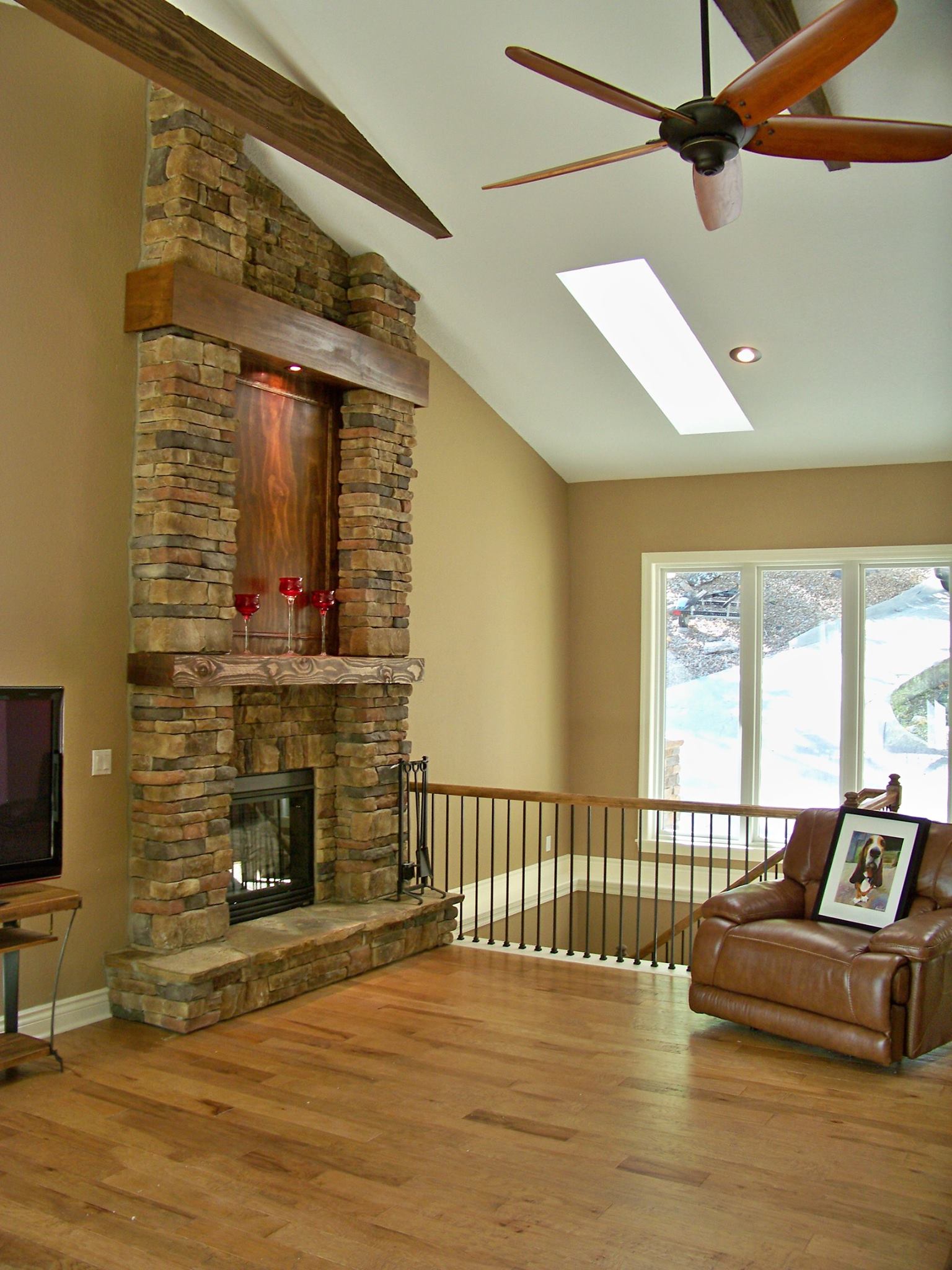 A living room with a fireplace and a ceiling fan
